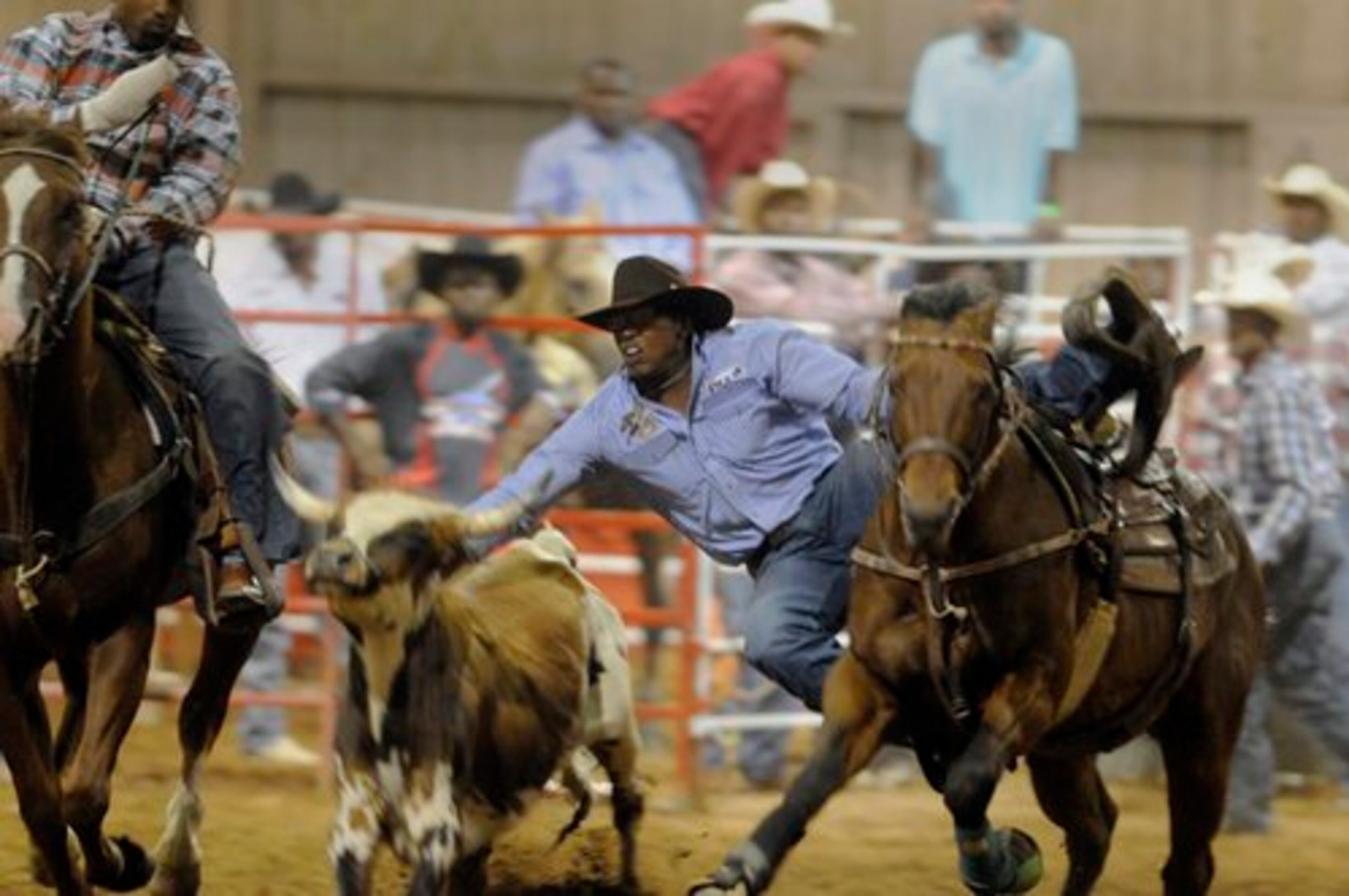 Denard Butler of Atlanta jumps off his horse to take down a calf in the bull doggin event Saturday evening.