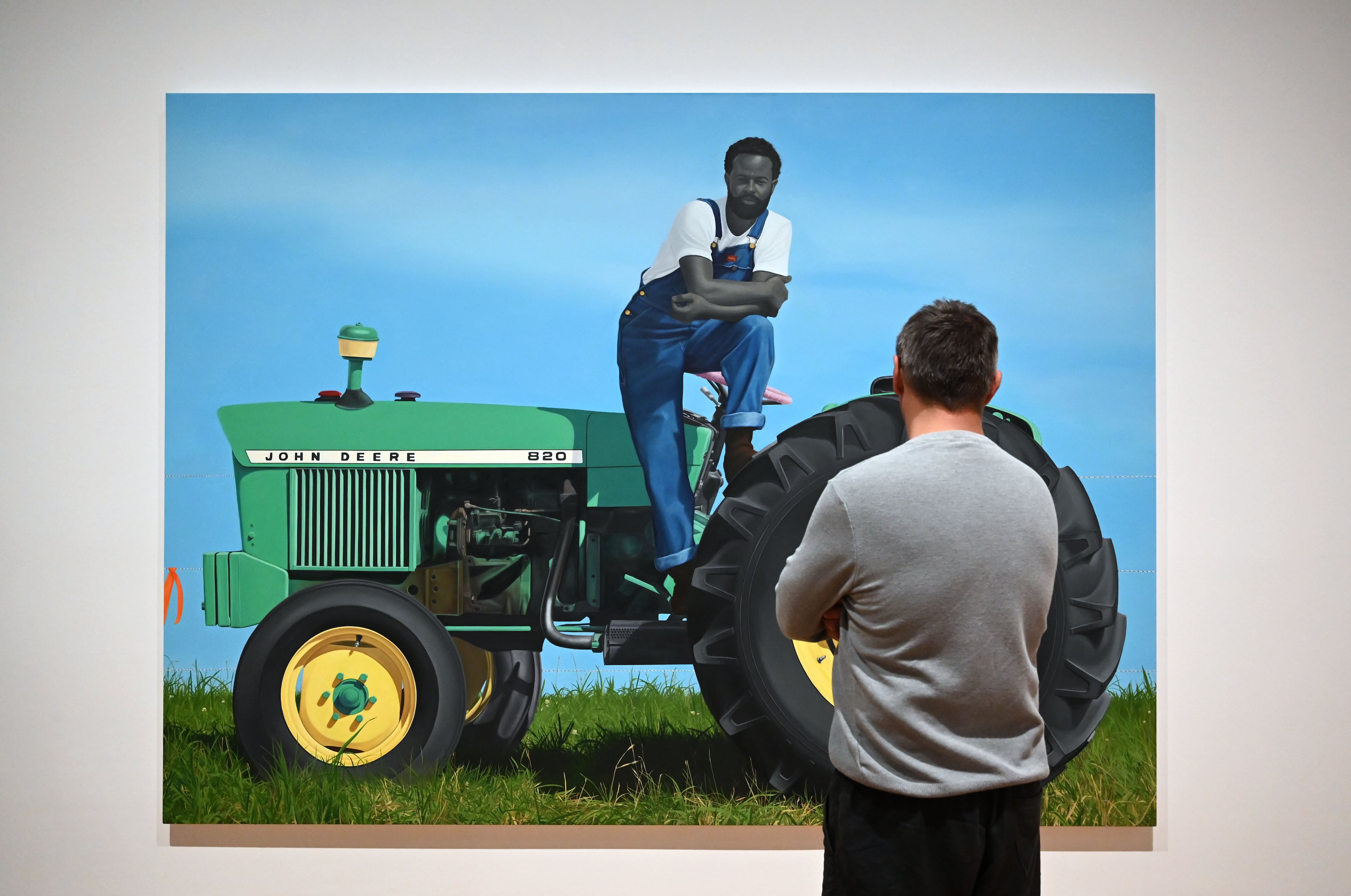 "A God Blessed Land (Empire of Dirt)" captivates a viewer in Sherald's “American Sublime” exhibition. (Hyosub Shin/AJC)