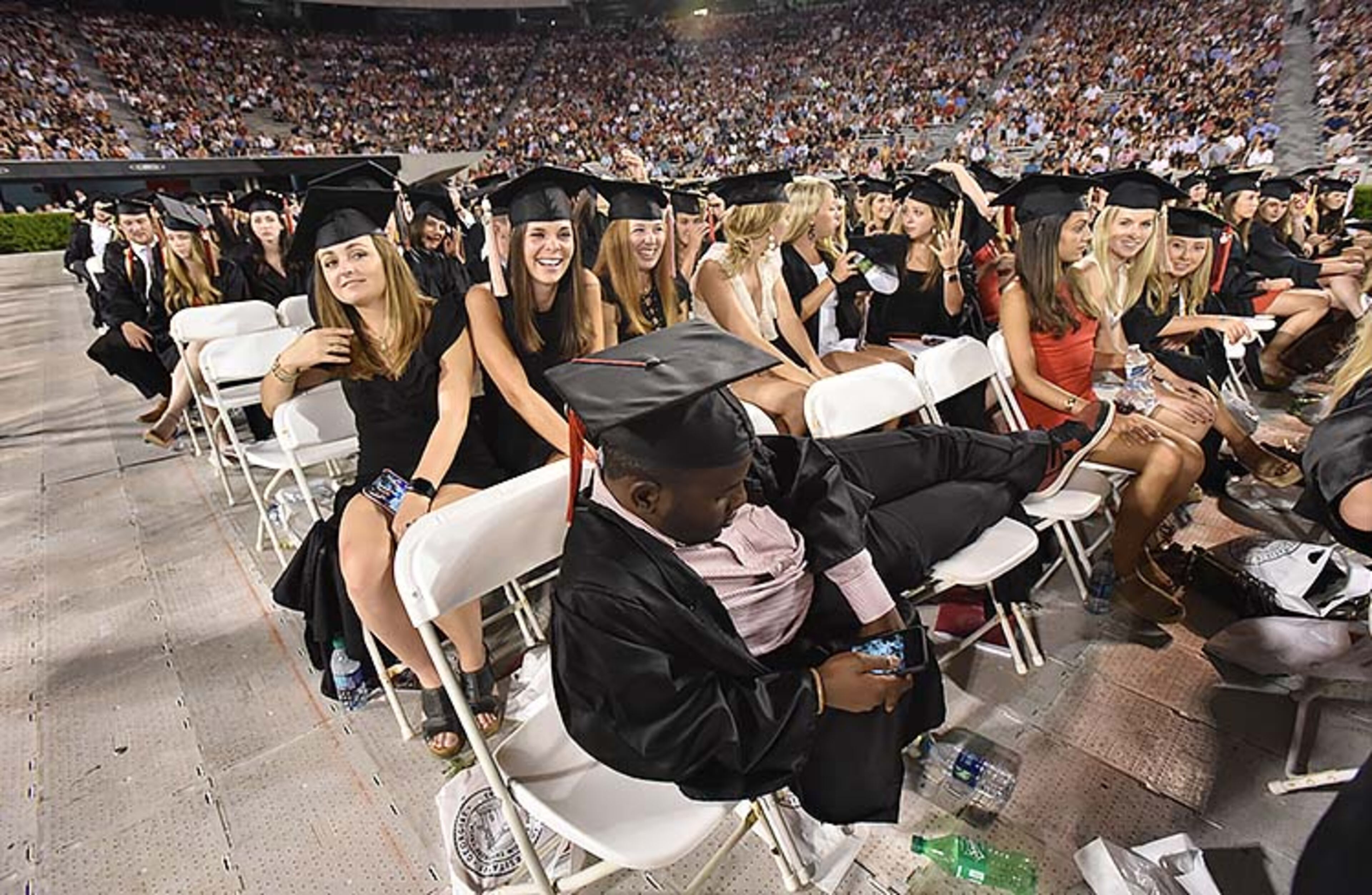 May 10, 2019 Athens - Takunda Mafundikwa makes himself comfortable during UGA's 2019 spring undergraduate commencement ceremony at Sanford Stadium in Athens on Friday, May 10, 2019. HYOSUB SHIN / HSHIN@AJC.COM