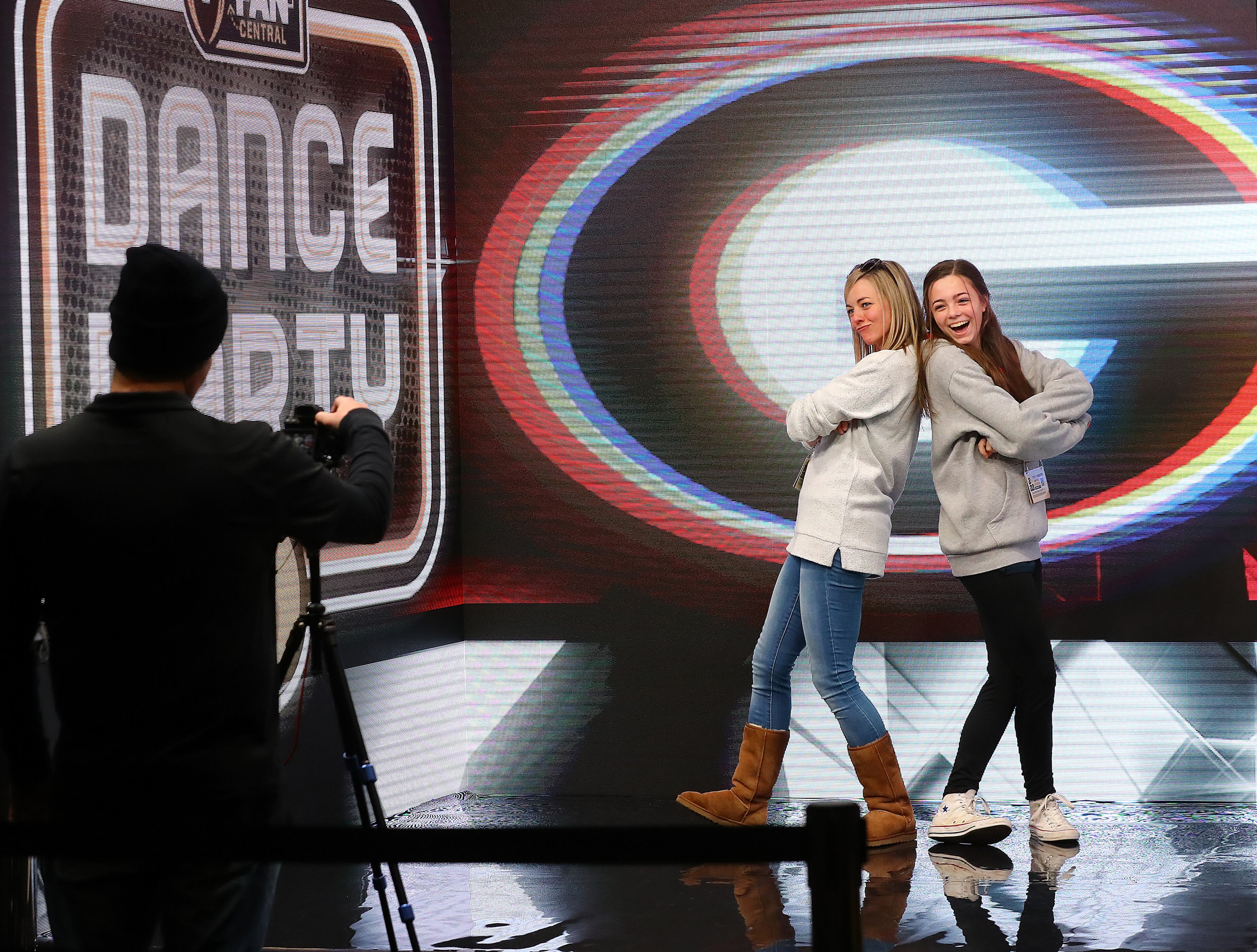 Deborah Lawler and her daughter Catelyn, 14, Athens, show off their moves in the Dance Party video booth while taking in the fan festival inside the Indianapolis Convention Center on Saturday, Jan. 8, 2022, in Indianapolis. The 200,000-square-foot interactive fan festival includes games, youth sports clinics, pep rallies and exhibits celebrating college football and its history. “Curtis Compton / Curtis.Compton@ajc.com”`