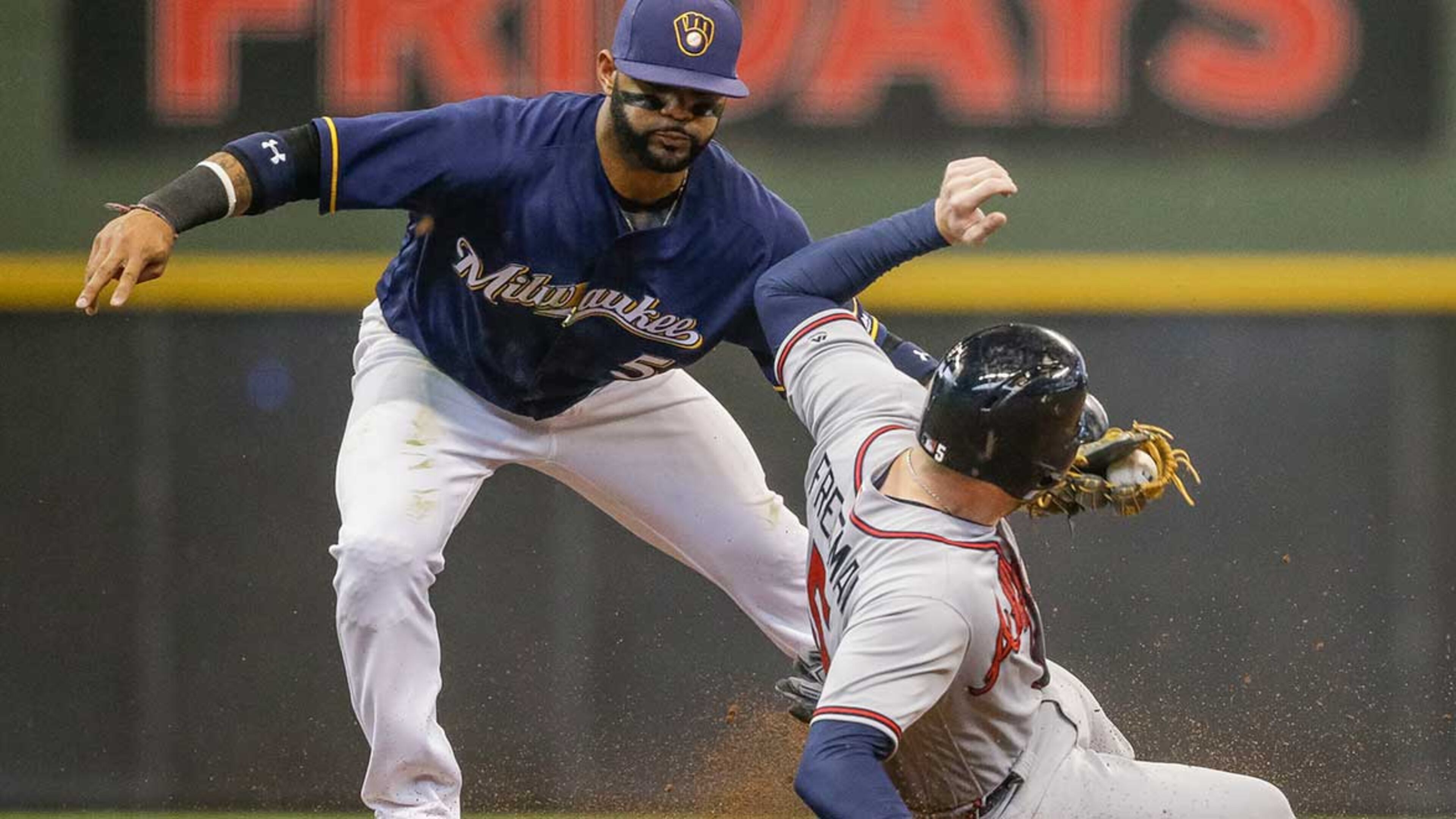 Jonathan Villar puts the tag on Freddie Freeman, who was caught attempting to steal second during the eighth inning of Sunday's game.