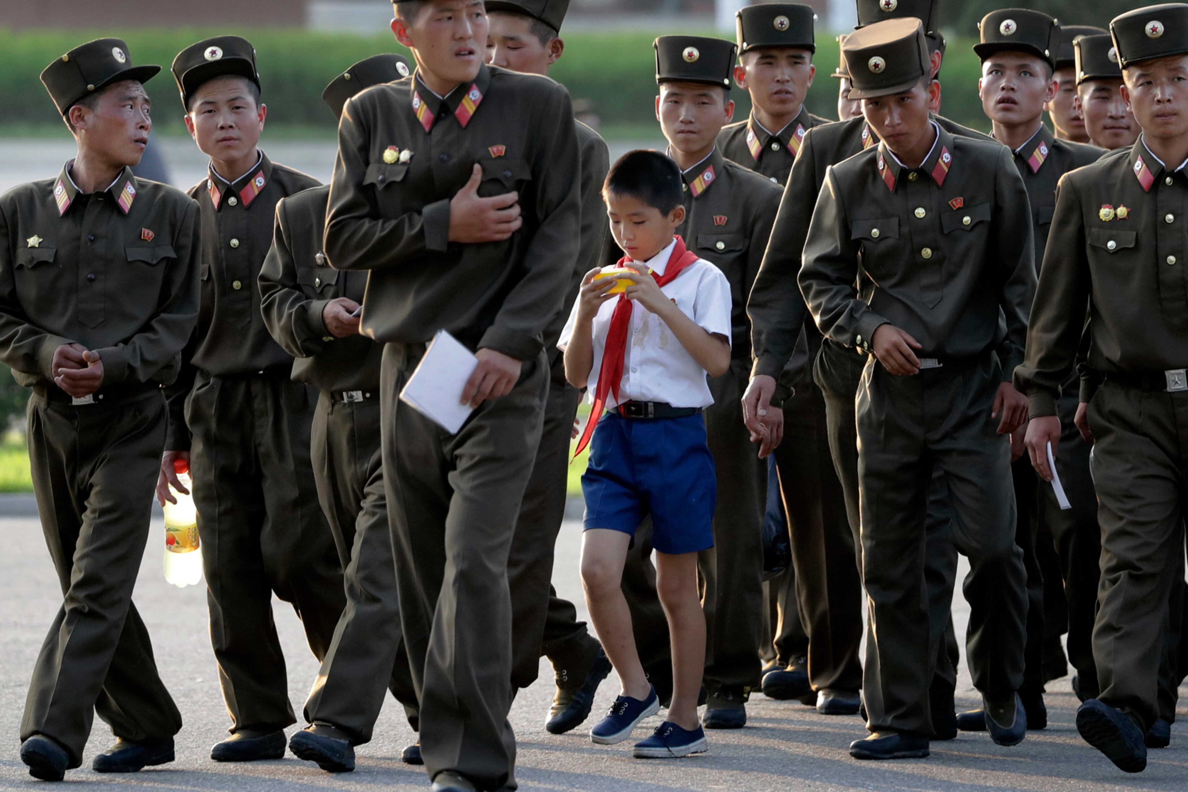 A school boy walks among soldiers at the end of a work day on Tuesday, July 25, 2017, in Pyongyang, North Korea. (AP Photo/Wong Maye-E)