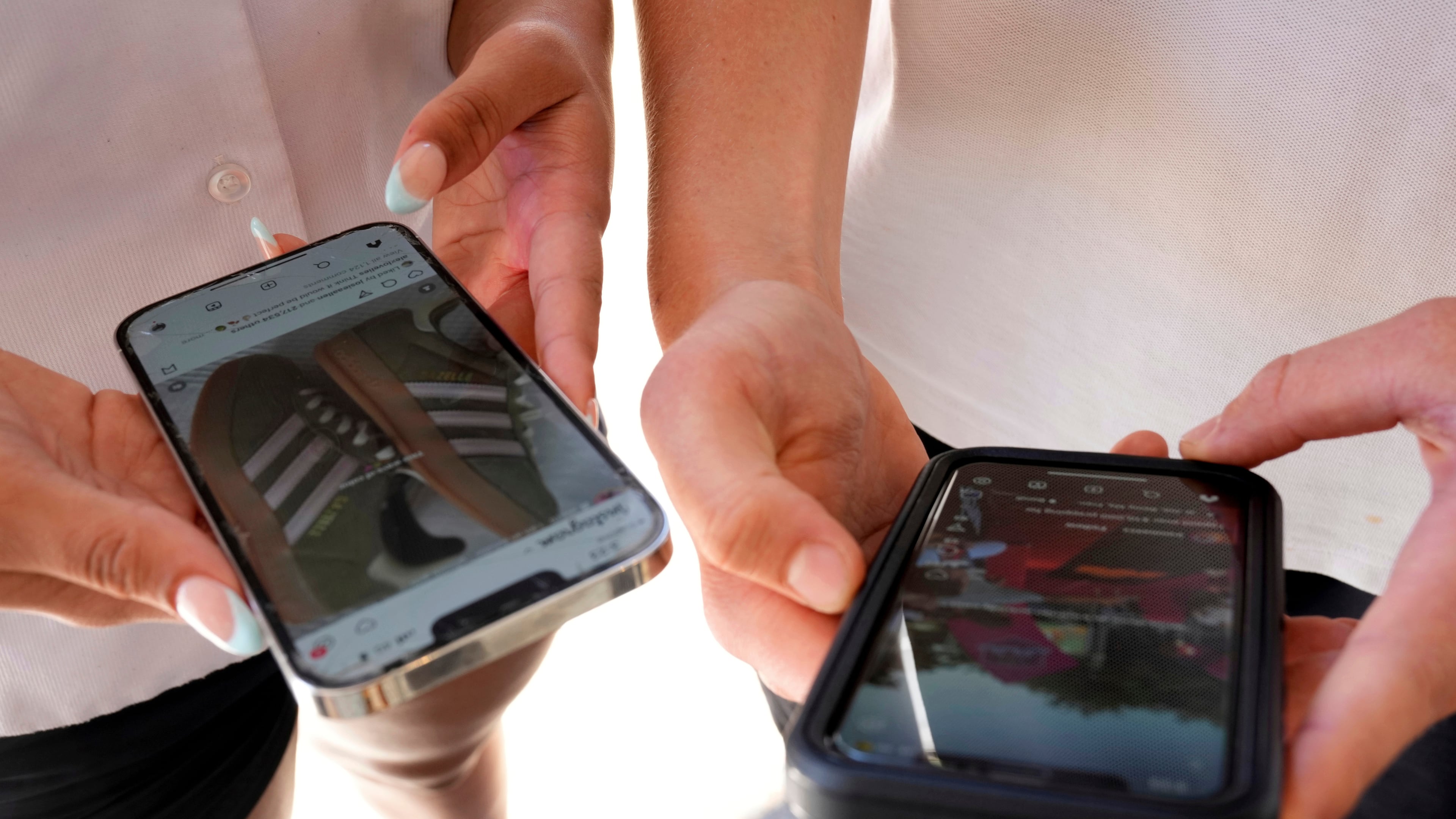FILE - Young people use their phones to view social media in Sydney on Nov. 8, 2024. (AP Photo/Rick Rycroft, File)