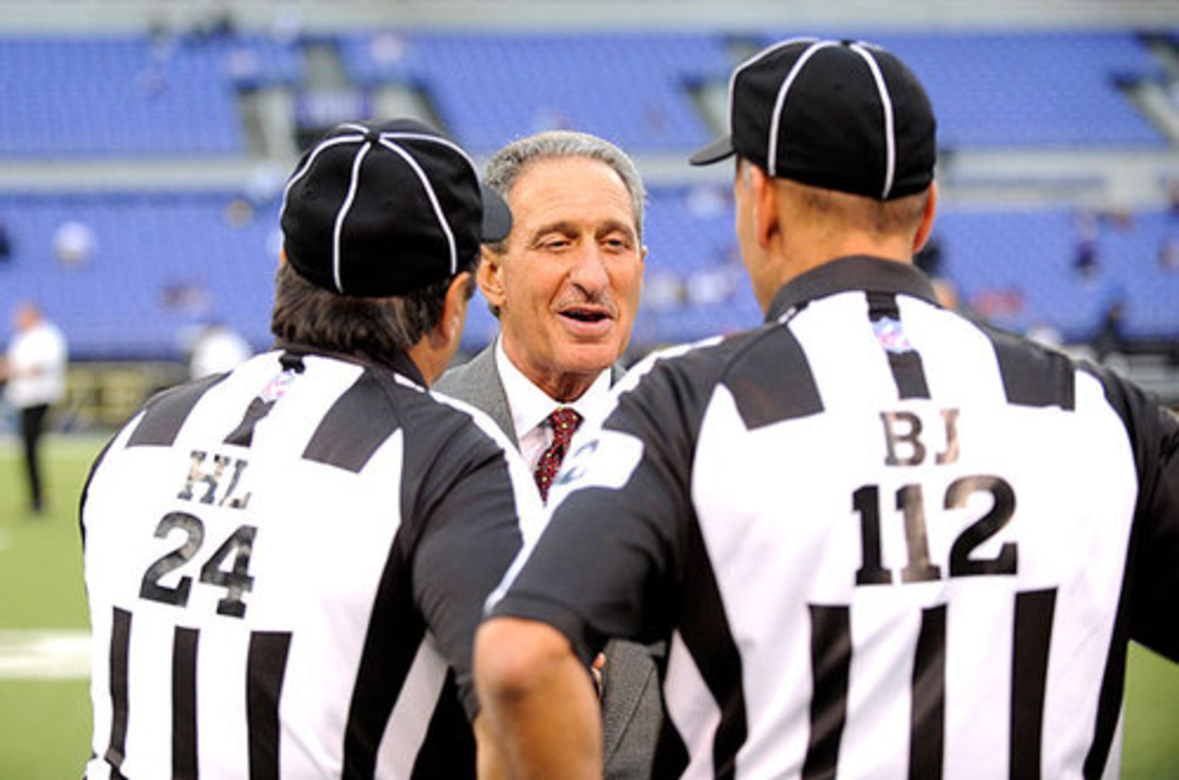 Falcons owner Arthur Blank talks to the officials before Thursday's game against the Ravens.