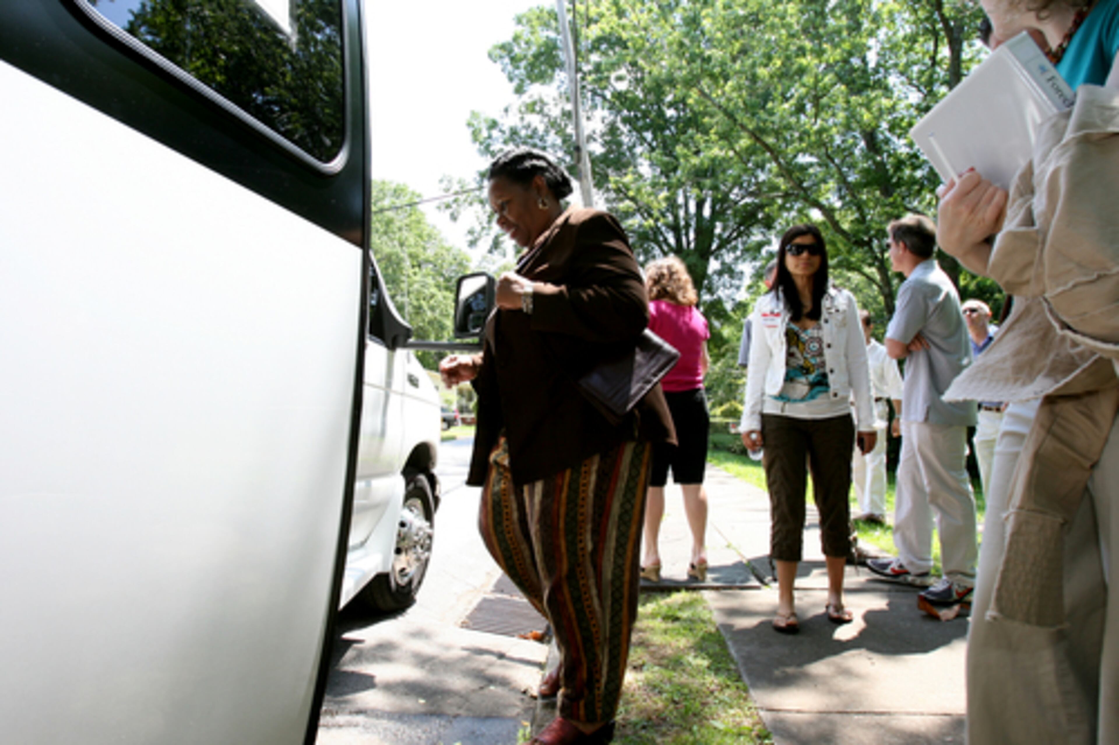 Pat Finley steps back onto the foreclosure tour bus after examining a foreclosed home on Leyden Street in Decatur.