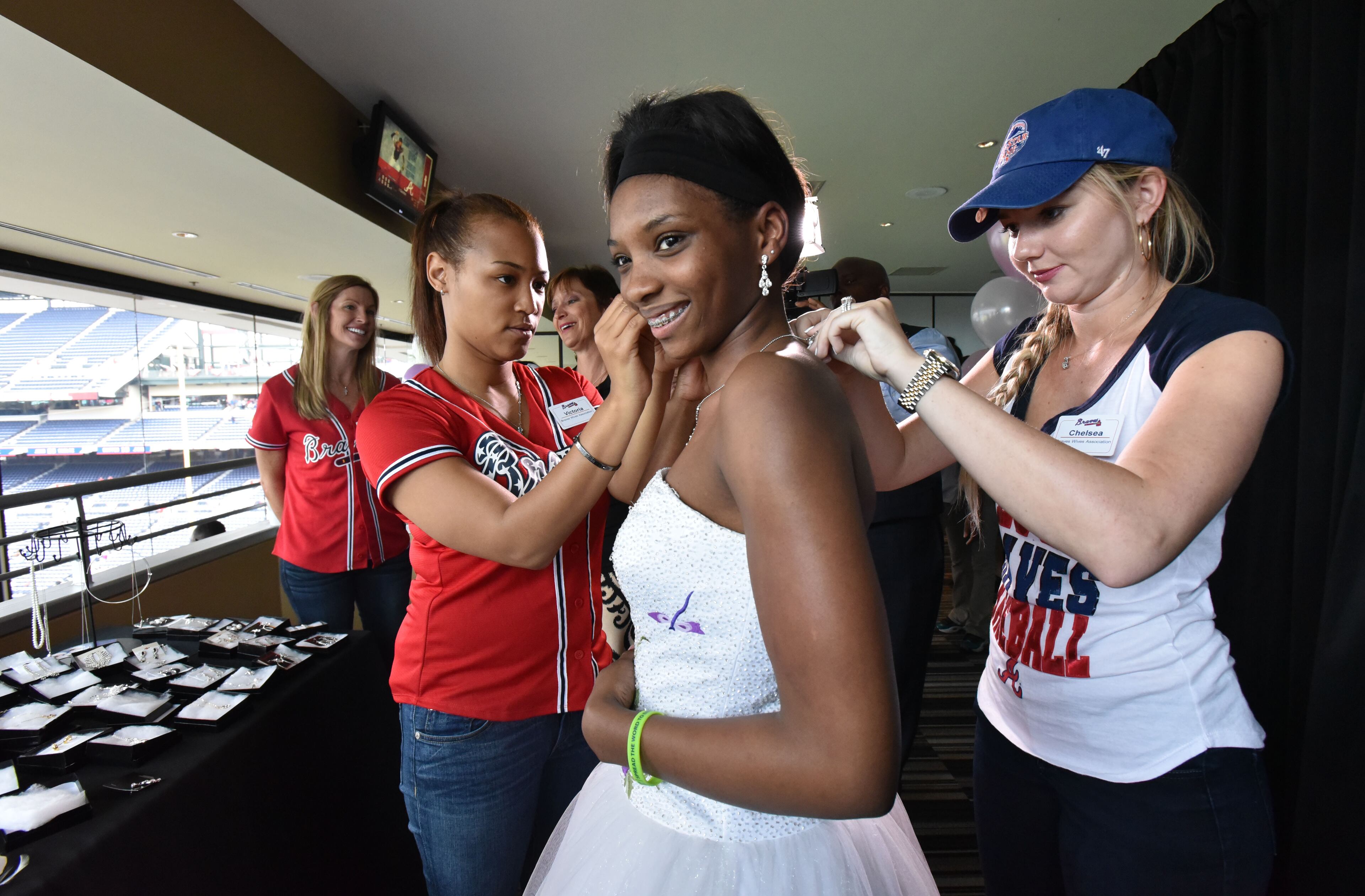 Atlanta Braves center fielder Eric Young's wife Victoria Young (left) and first baseman Freddie Freeman's wife Chelsea Freeman (right) help Keyarra Mason, 16, choose a necklace to match her new prom dress before the Atlanta Braves home game against the Miami Marlins at Turner Field in Atlanta on Tuesday, April 14, 2015. HYOSUB SHIN / HSHIN@AJC.COM