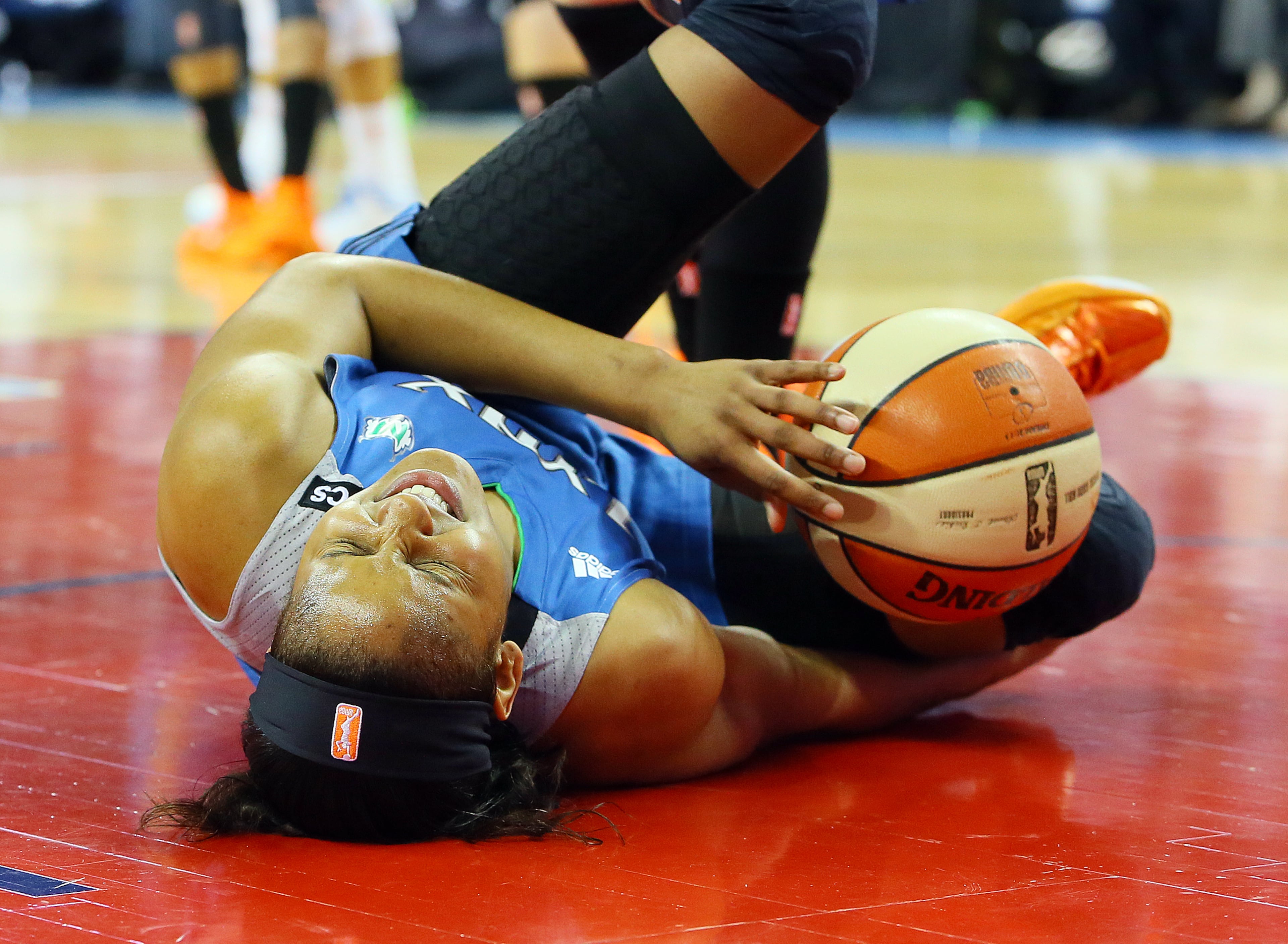 Lynx forward Maya Moore wins the rebound battle with the Dream but reacts in pain as she hits the hardwood with the ball during the first half of their WNBA Finals basketball game 3 on Thursday, Oct. 10, 2013, in Duluth. The Lynx went on to win 86-77.
