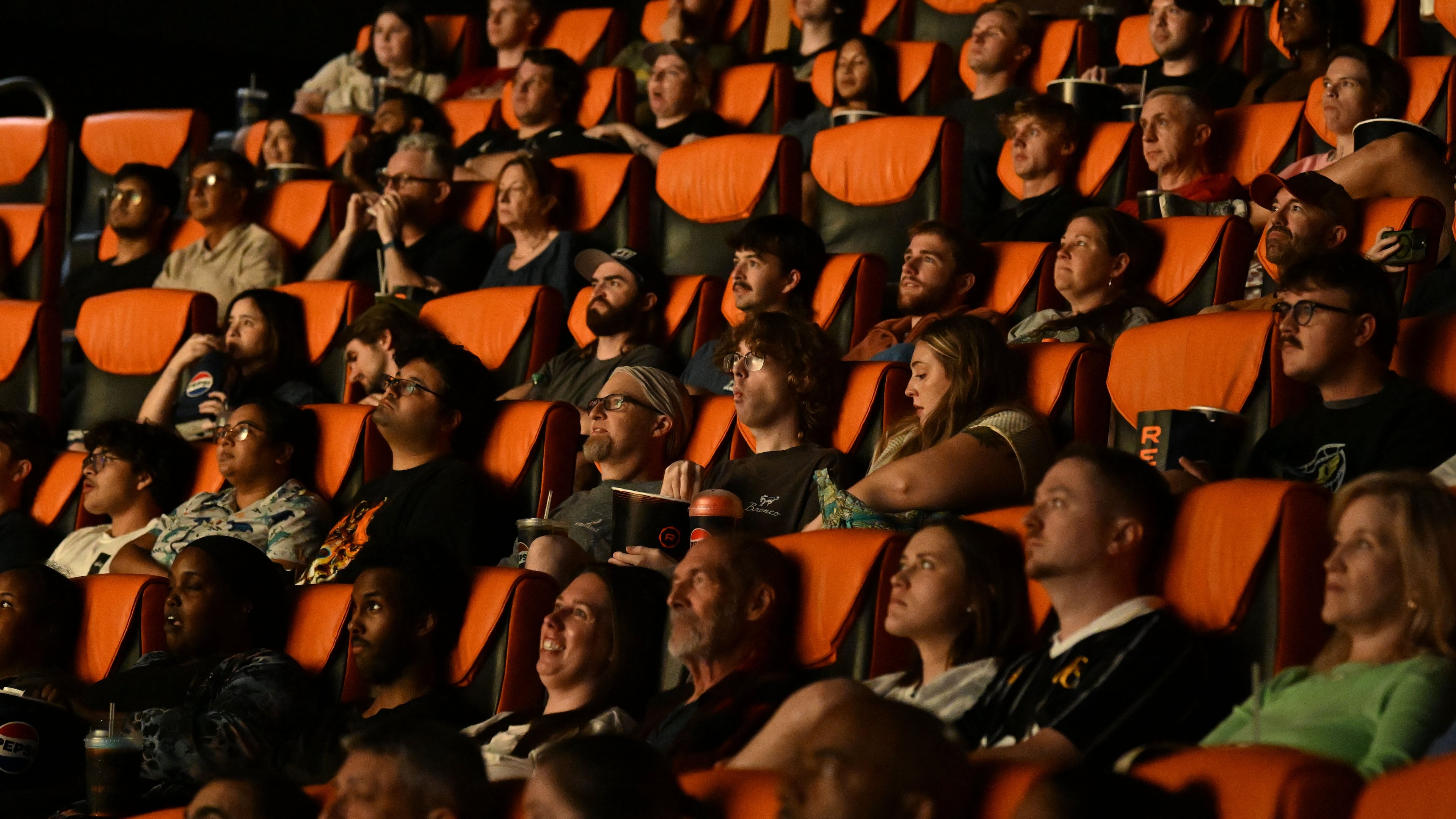 Moviegoers watch previews before a screening of “The Odyssey,” presented in IMAX 70mm film, at the Regal Mall of Georgia on Friday, Aug. 7, 2026, in Buford. The theater has been open for 24 hours Thursday through Monday since the film’s release. (Hyosub Shin/AJC)