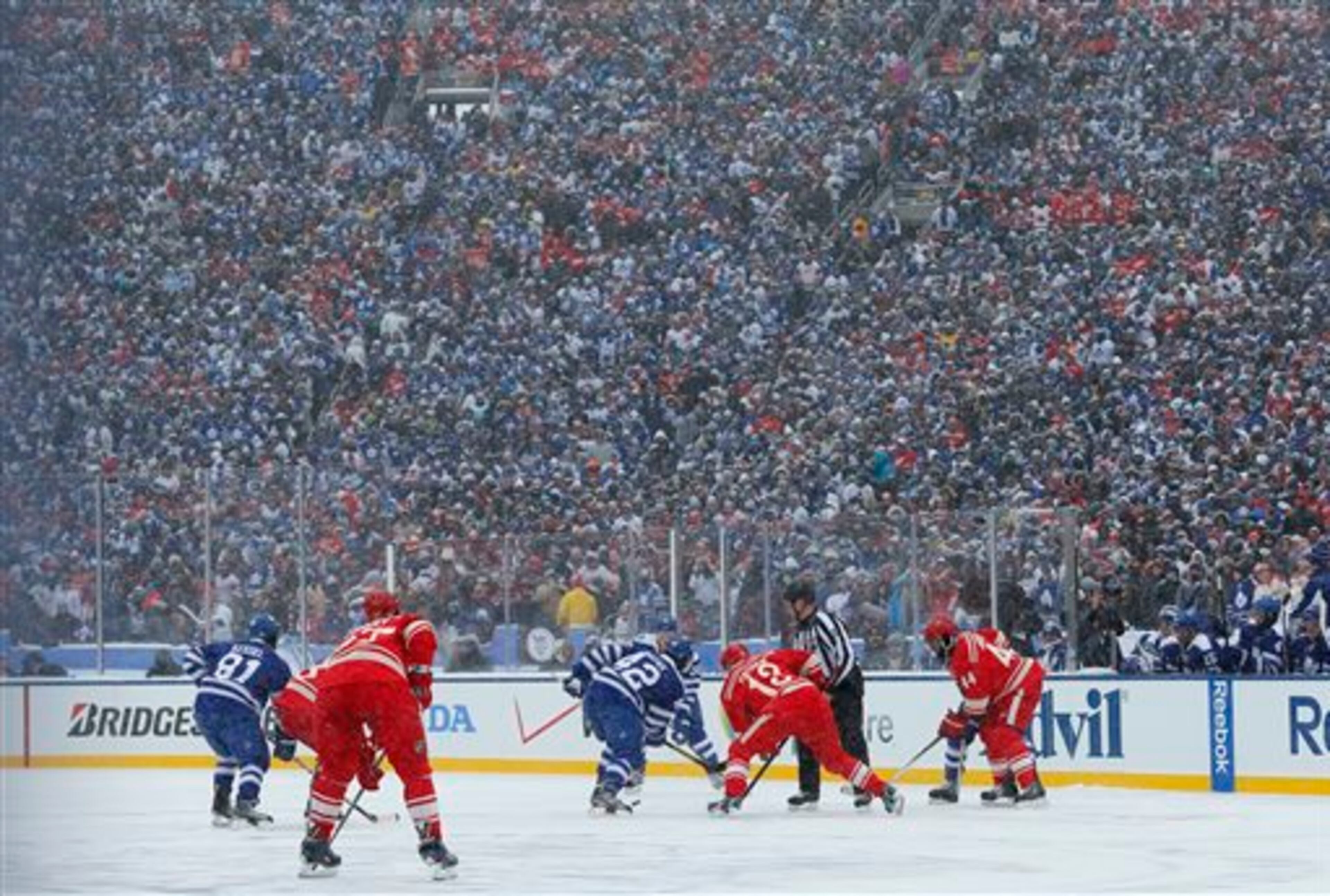 The Toronto Maple Leafs and the Detroit Red Wings face off during the first period of the Winter Classic outdoor NHL hockey game at Michigan Stadium in Ann Arbor, Mich., Wednesday, Jan. 1, 2014. (AP Photo/Paul Sancya)