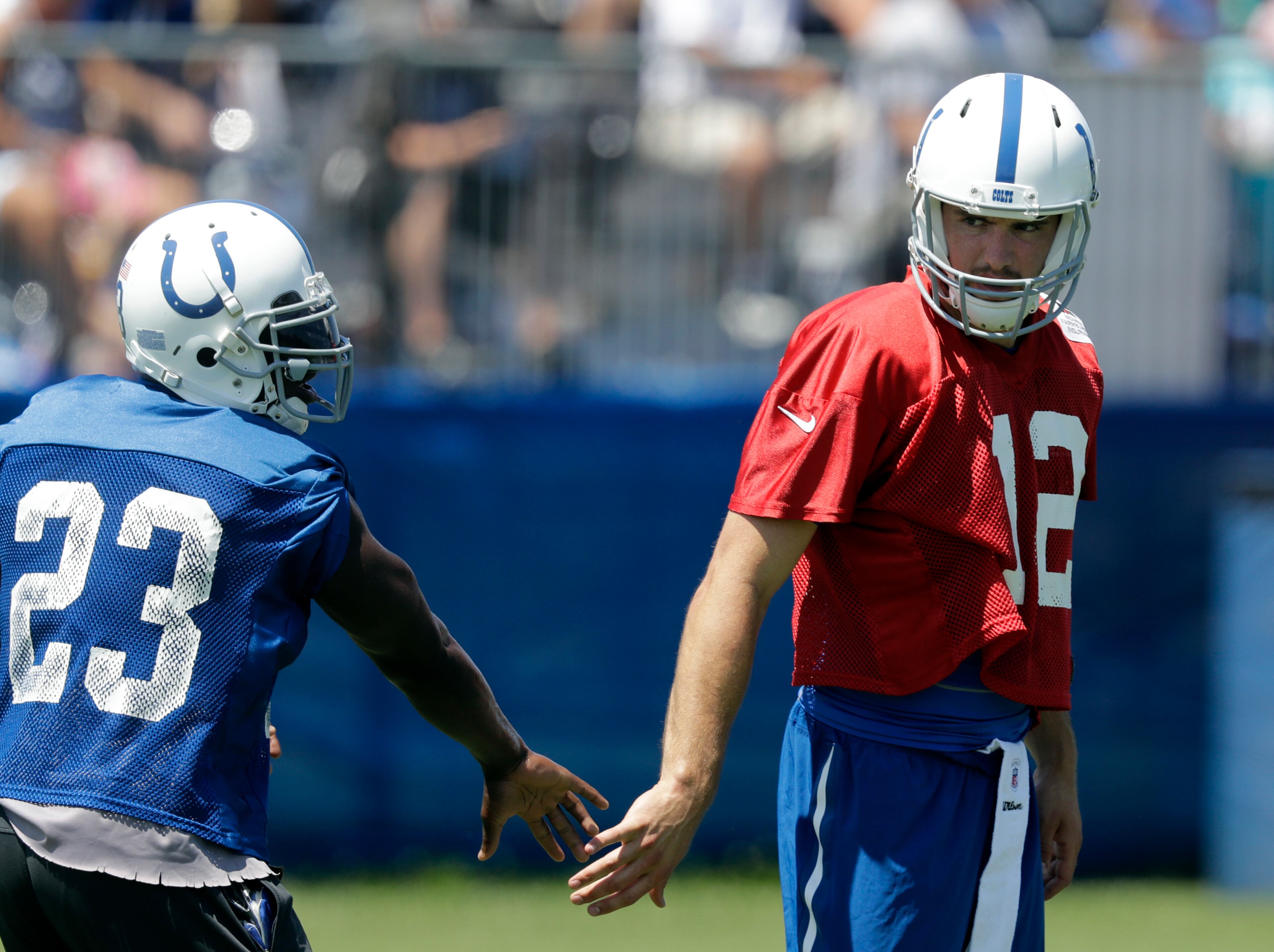 Indianapolis Colts running back Frank Gore and quarterback Andrew Luck slap hands during an NFL football training camp, Wednesday, July 27, 2016, in Anderson, Ind. (AP Photo/Darron Cummings)
