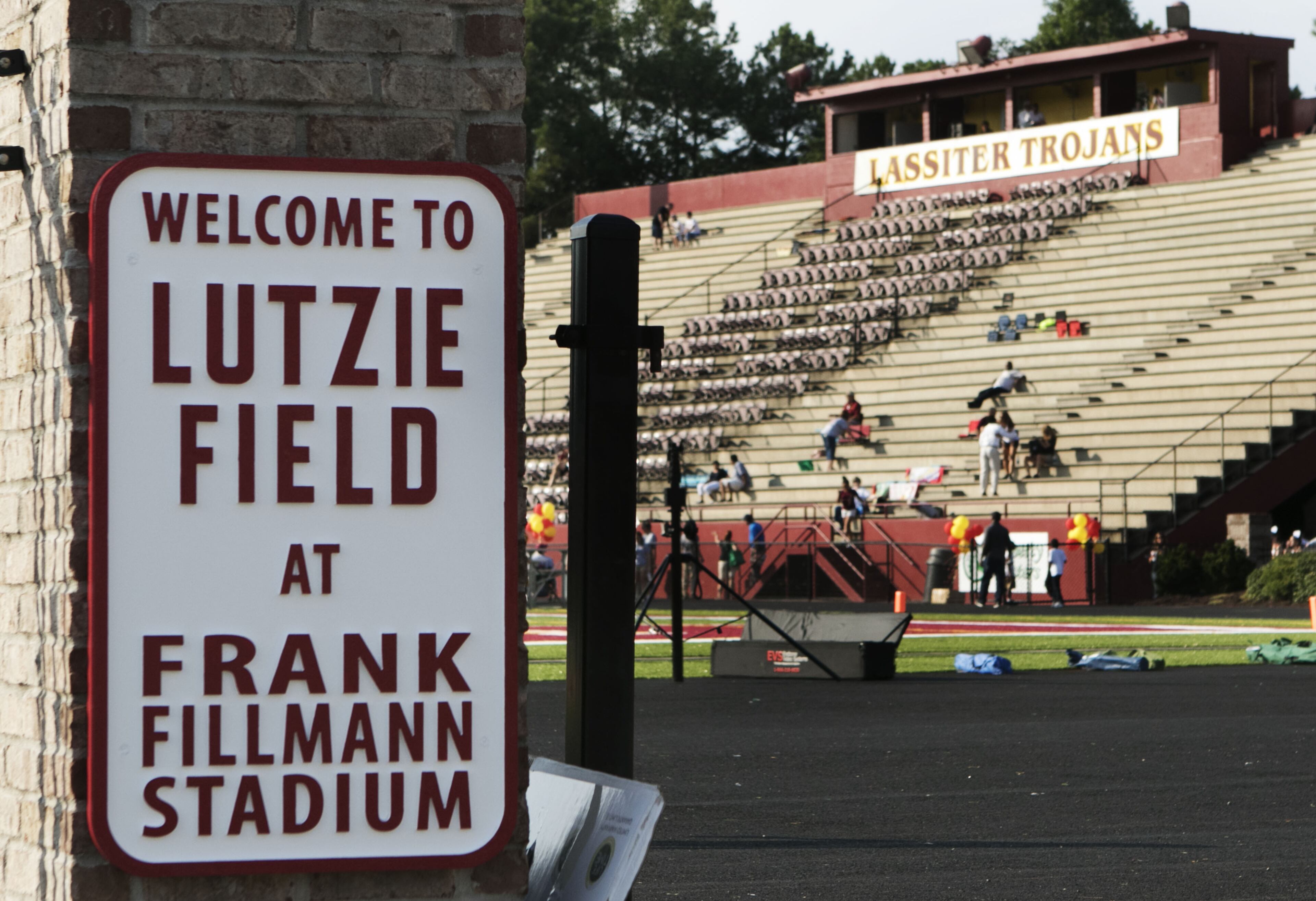 The family of the late fullback Philip Lutzenkirchen witness the dedication of the newly resurfaced and newly named Lutzie Field at Lassiter High in Marietta on Friday August 14th, 2015. (Photo by Phil Skinner)
