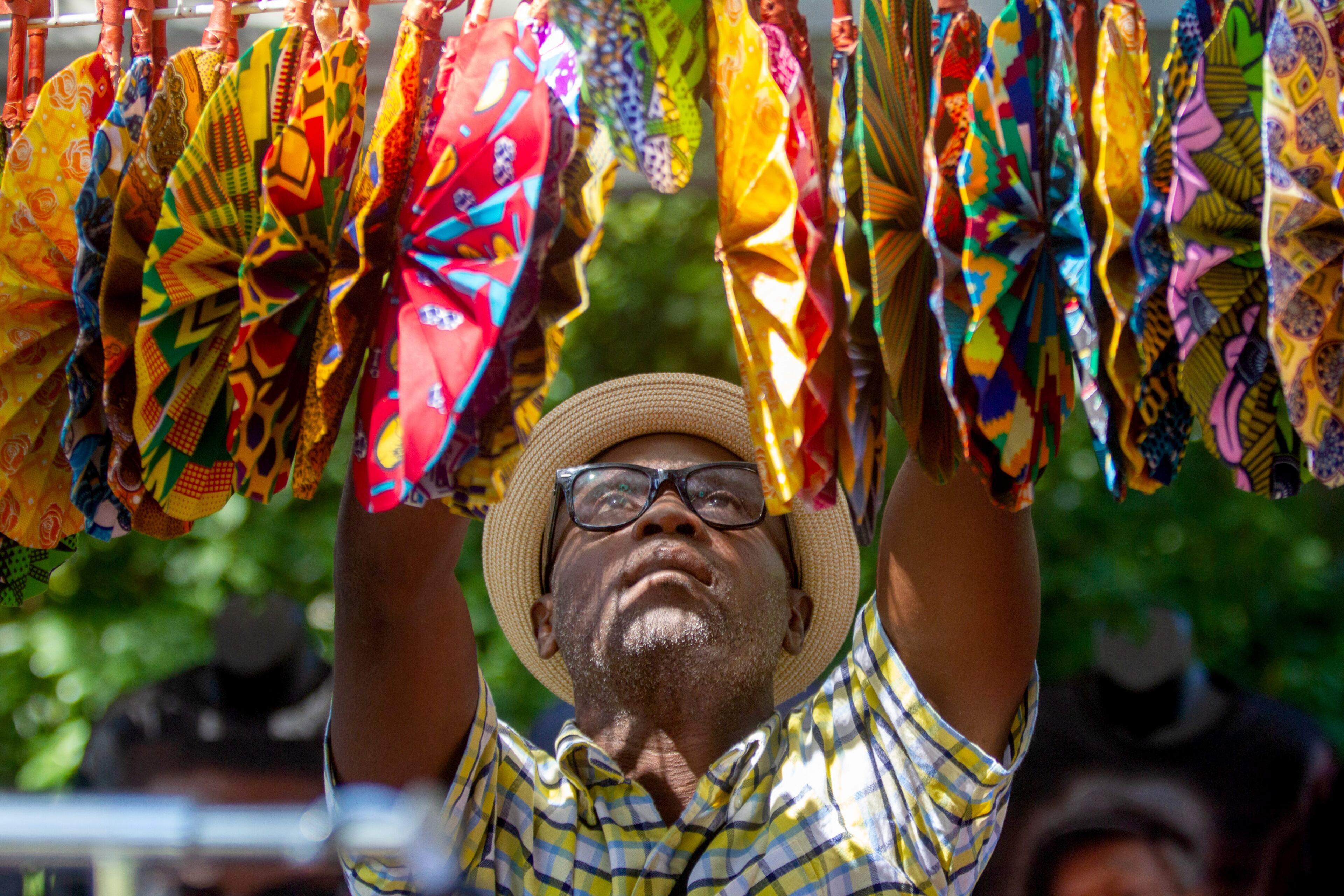 Emolo Sampah arranges colorful fans in his vendor booth during the Atlanta Jazz Festival in Piedmont Park on Sunday, September 5, 2021. STEVE SCHAEFER FOR THE ATLANTA JOURNAL-CONSTITUTION