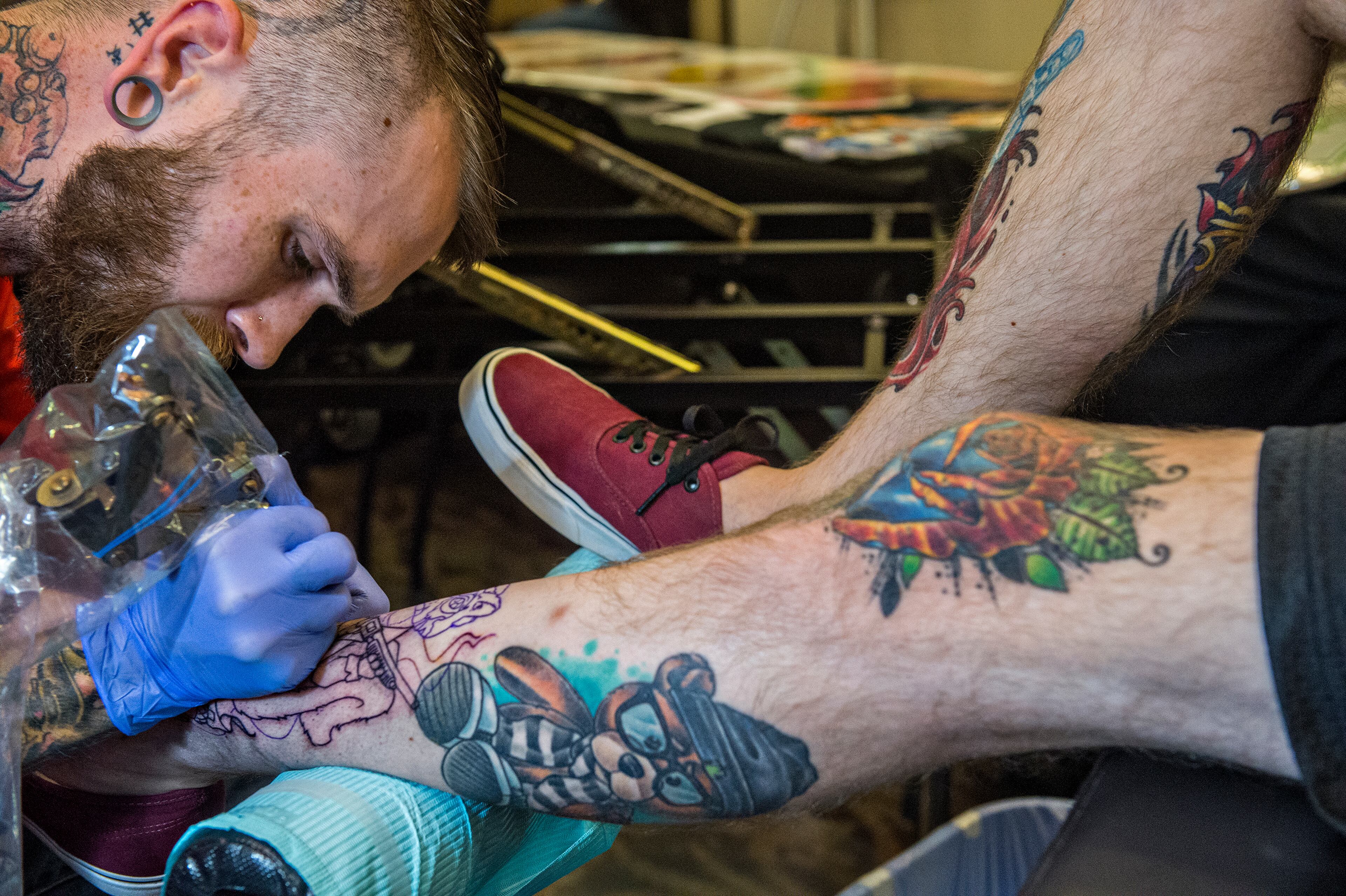 June 20, 2015 Atlanta - Mat Purdy (left) adds a fresh tattoo to Jake DeValk's collection on his legs during the 19th annual Atlanta Tattoo Expo at the Wyndham Atlanta Galleria hotel on Saturday, June 20, 2015. Around 100 tattoo artists from across the country were booked solid throughout the three day event as hundreds of people came out to watch and get tattooed. JONATHAN PHILLIPS / SPECIAL