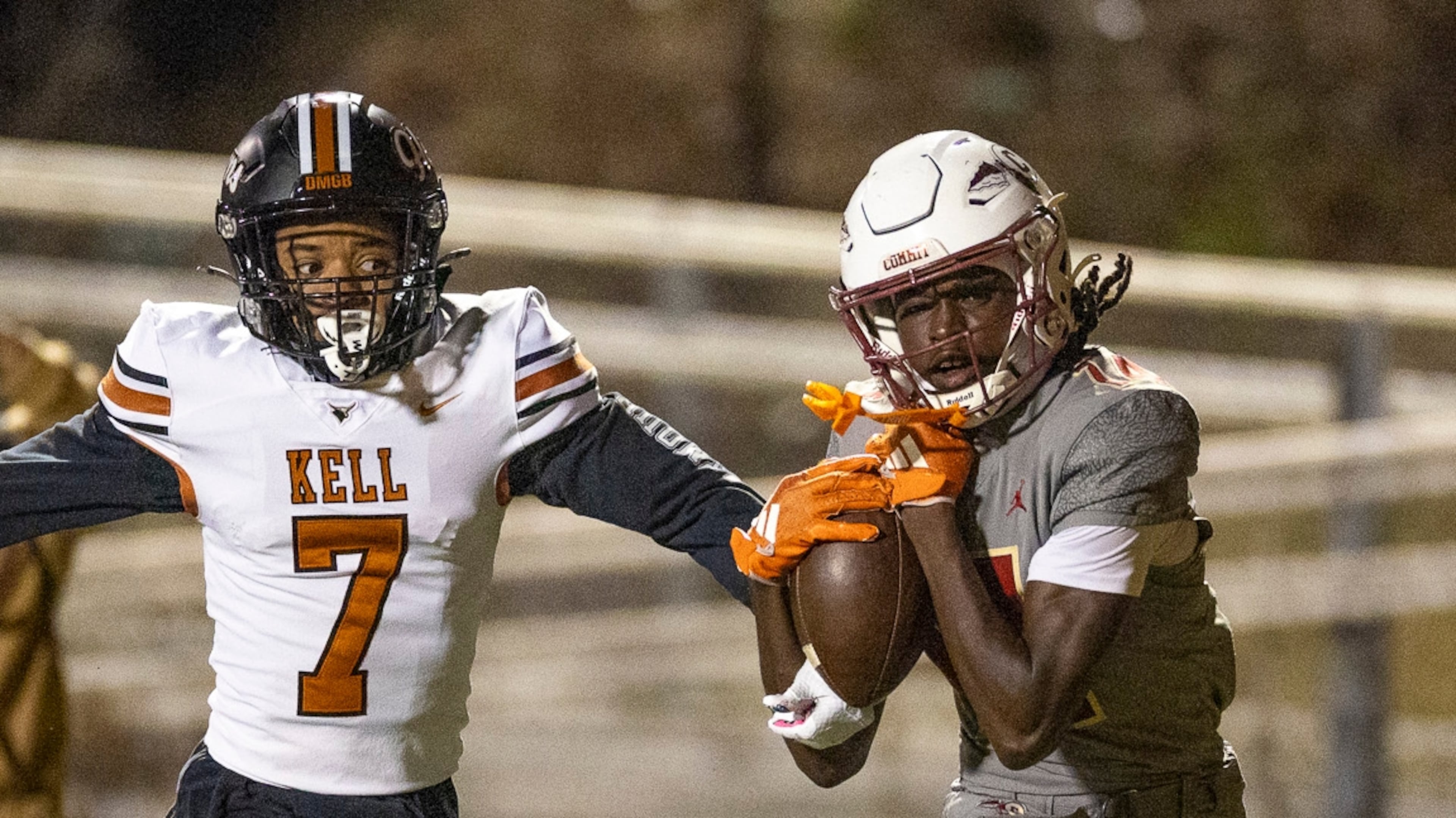 Creekside wide receiver Armani Hill (right) makes a catch while Kell defensive back Robert Tyson Jr. tries to intercept during the Class 4A semifinals last season. Both teams are playing in a higher class this season. (Oscar Guevara Saenz for the AJC)