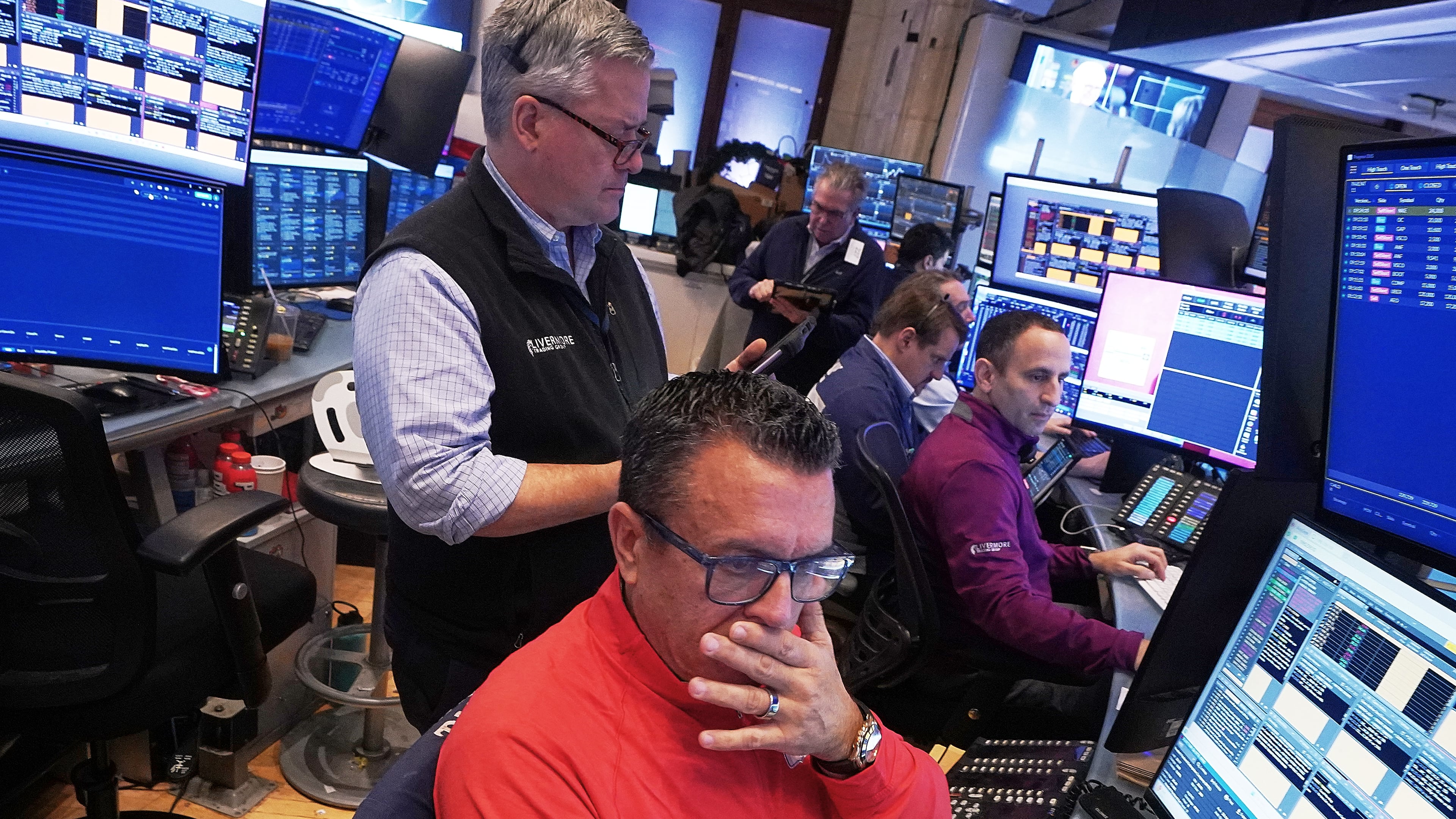 Trader Robert Finnerty Jr., foreground, works with colleagues on the floor of the New York Stock Exchange, Monday, Jan. 12, 2026. (AP Photo/Richard Drew)