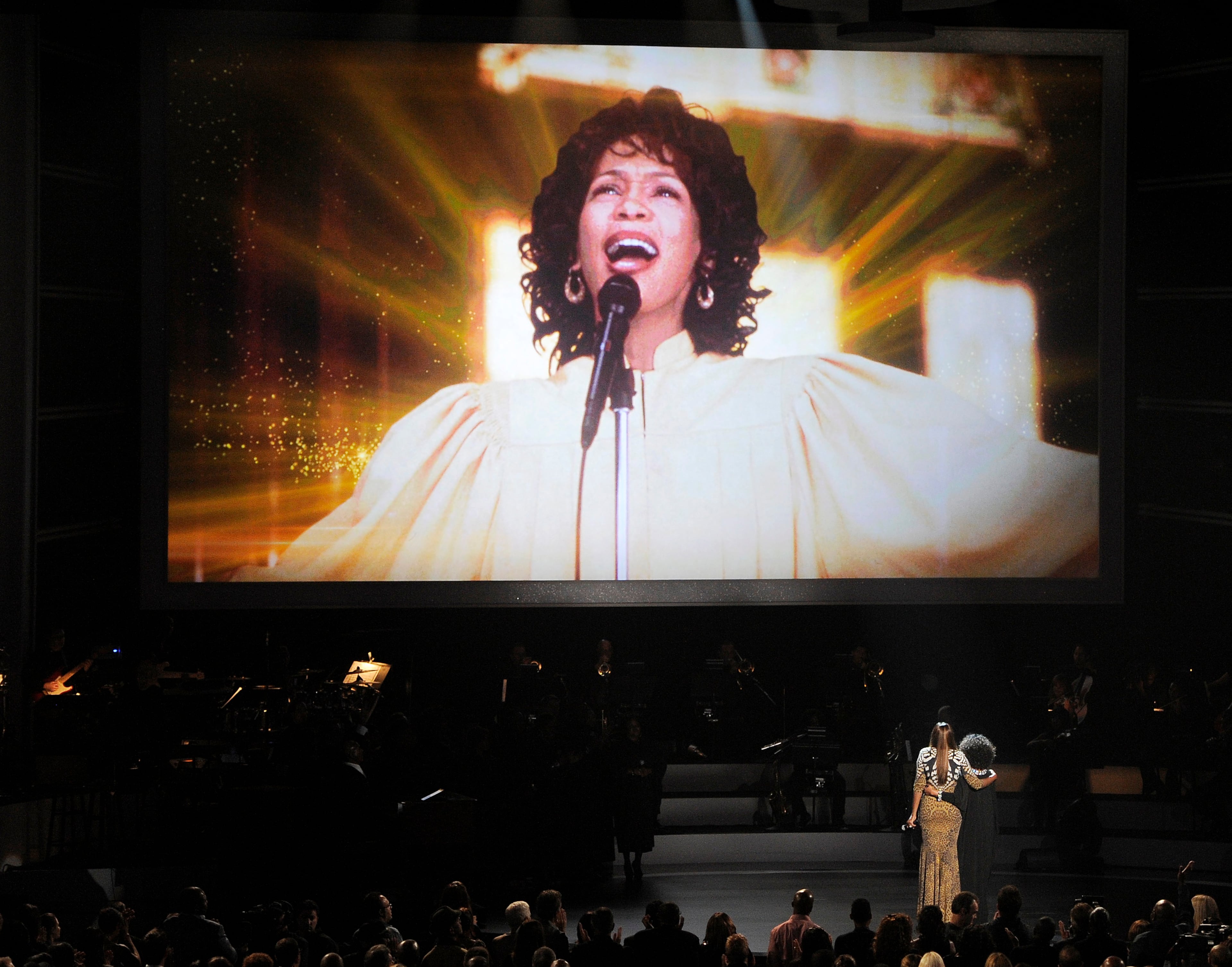 Singers Yolanda Adams and Cece Winans, bottom right, look up to an image of singer Whitney Houston after their performance onstage at "We Will Always Love You: A Grammy Salute to Whitney Houston," at Nokia Theatre on Thursday, Oct. 11, 2012, in Los Angeles. The one-hour concert tribute will air on CBS on Nov. 16.