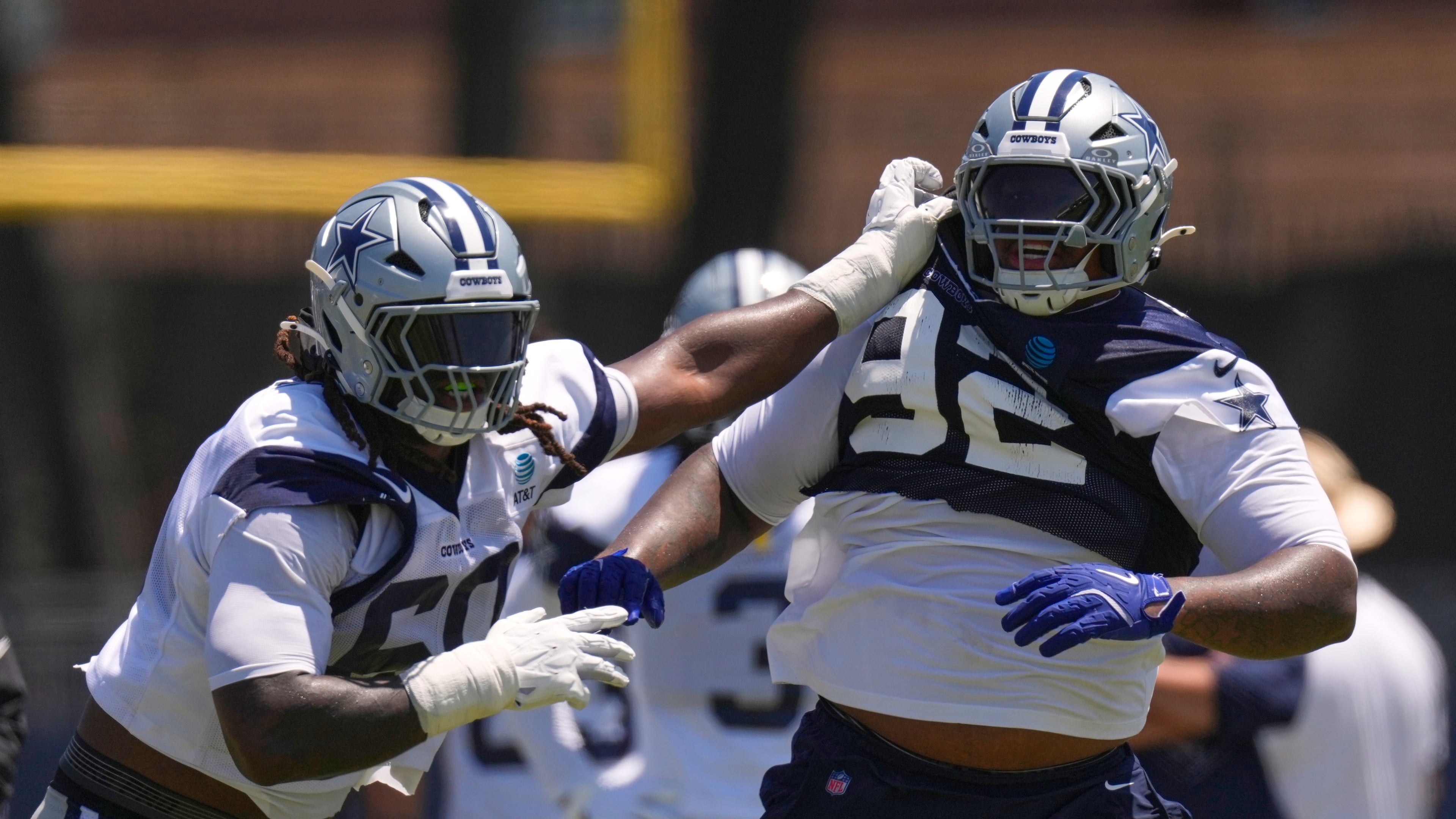 Dallas Cowboys offensive tackle Tyler Guyton, left, holds defensive tackle Quinnen Williams back during the NFL football team's training camp, Saturday, Aug. 1, 2026, in Oxnard, Calif. (AP Photo/Mark J. Terrill)