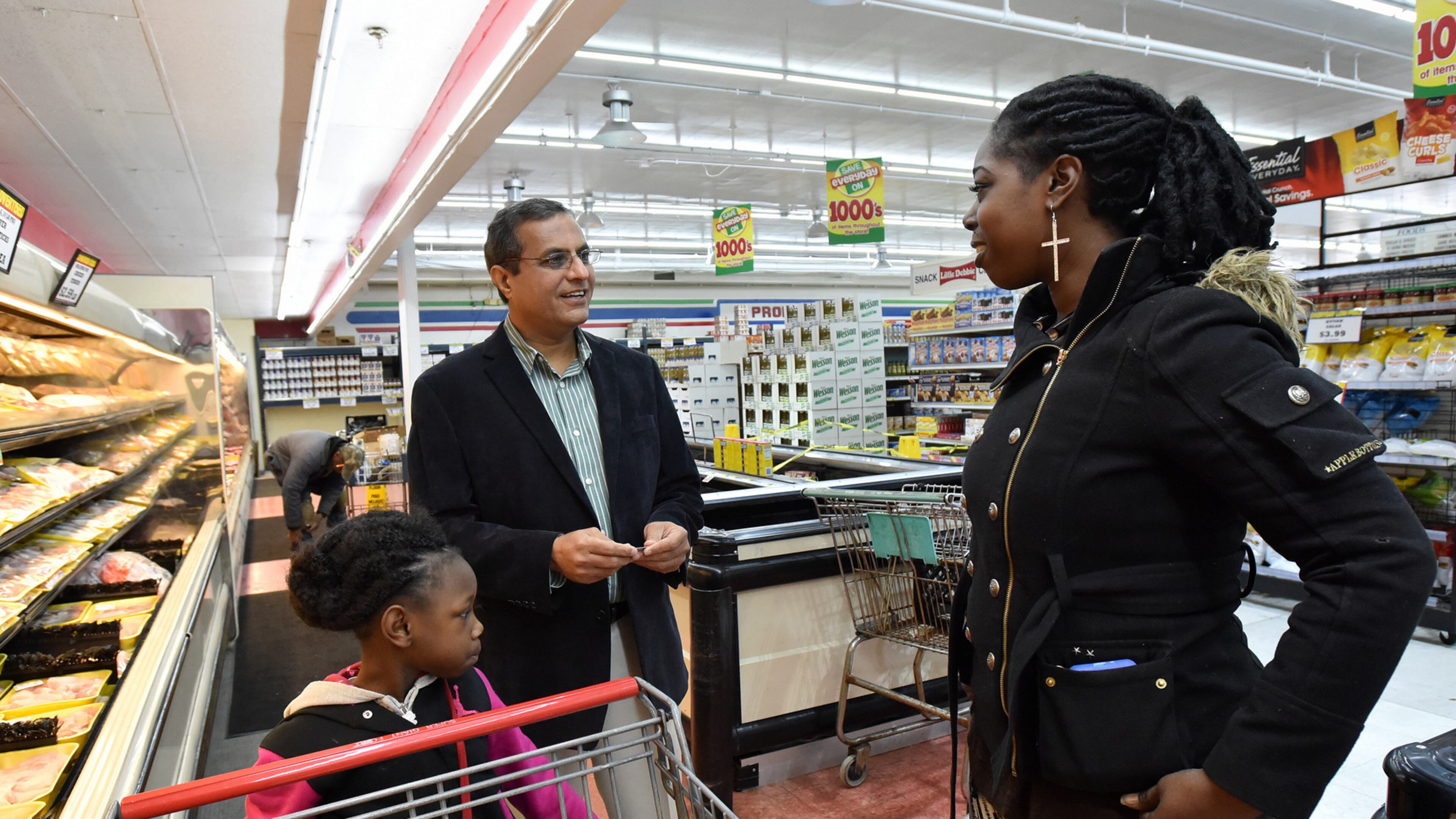 February 6, 2015 Atlanta - Sam Goswami (center), owner of the Super Giant Foods, talks with his customer Inga Carter, of Atlanta, with her daughter Tiyonah, 7, at Super Giant Food in Atlanta on Friday, February 6, 2015. Sam Goswami, owner of the Super Giant Foods on Atlanta's Westside, knows what food means to his customers. Every day in the checkout lines, he sees who's planning a family celebration, what's on the holiday menu, and how folks are stretching their food budget to make ends meet. HYOSUB SHIN / HSHIN@AJC.COM