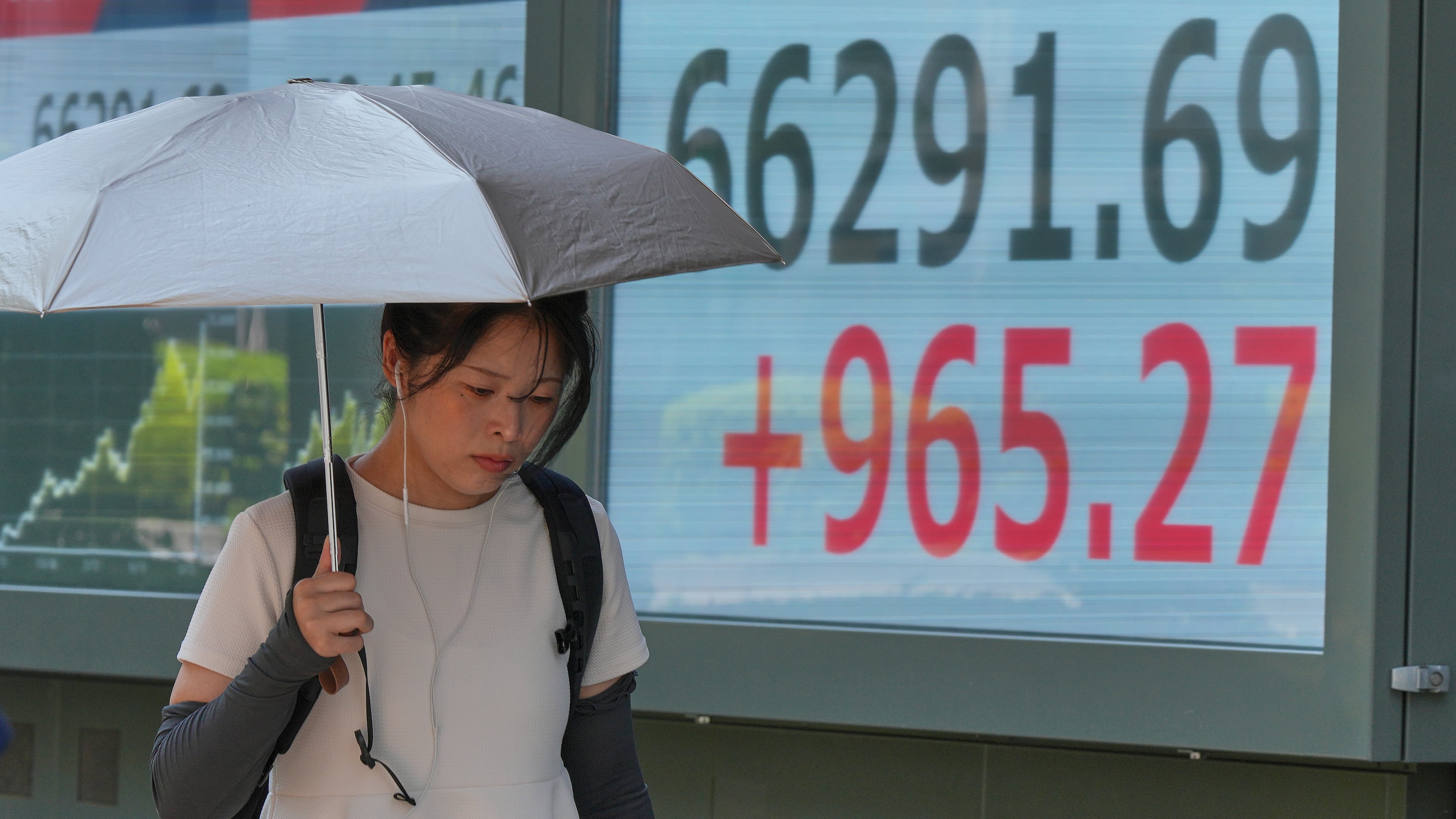 A person walks in front of an electronic stock board showing Japan's Nikkei index at a securities firm Thursday, Aug. 20, 2026, in Tokyo. (AP Photo/Eugene Hoshiko)