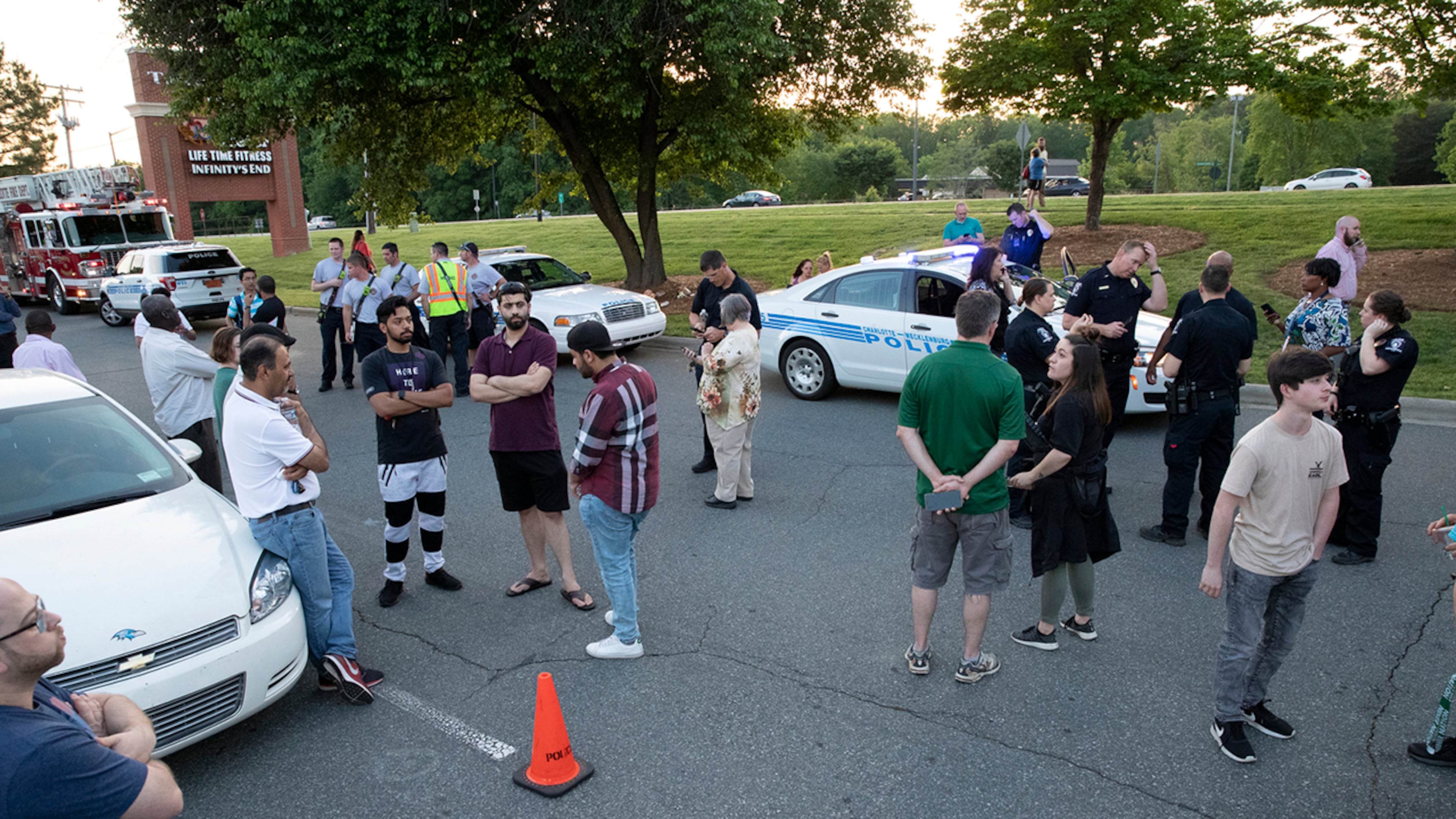 People gather across from the campus of UNC Charlotte after a shooting incident at the school Tuesday, April 30, 2019, in Charlotte, N.C.