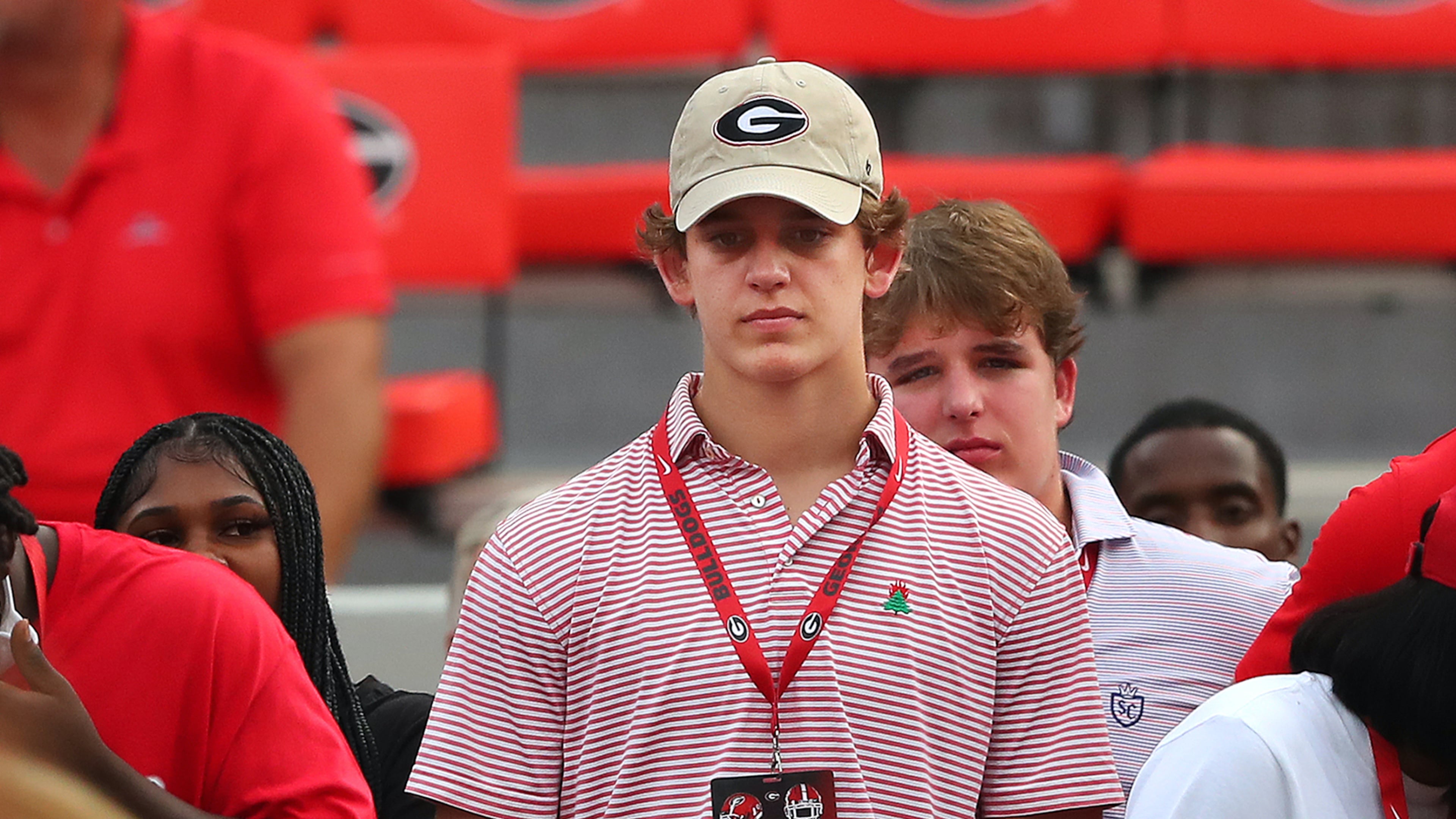 Recruit Arch Manning of New Orleans stands on the sideline wearing a Georgia cap while watching the Bulldogs go through pregame warmups before their game against South Carolina in 2021 in Athens. Manning is the son of Cooper Manning, nephew of Eli and Peyton Manning and grandson of Archie Manning. (Curtis Compton / Curtis.Compton@ajc.com)