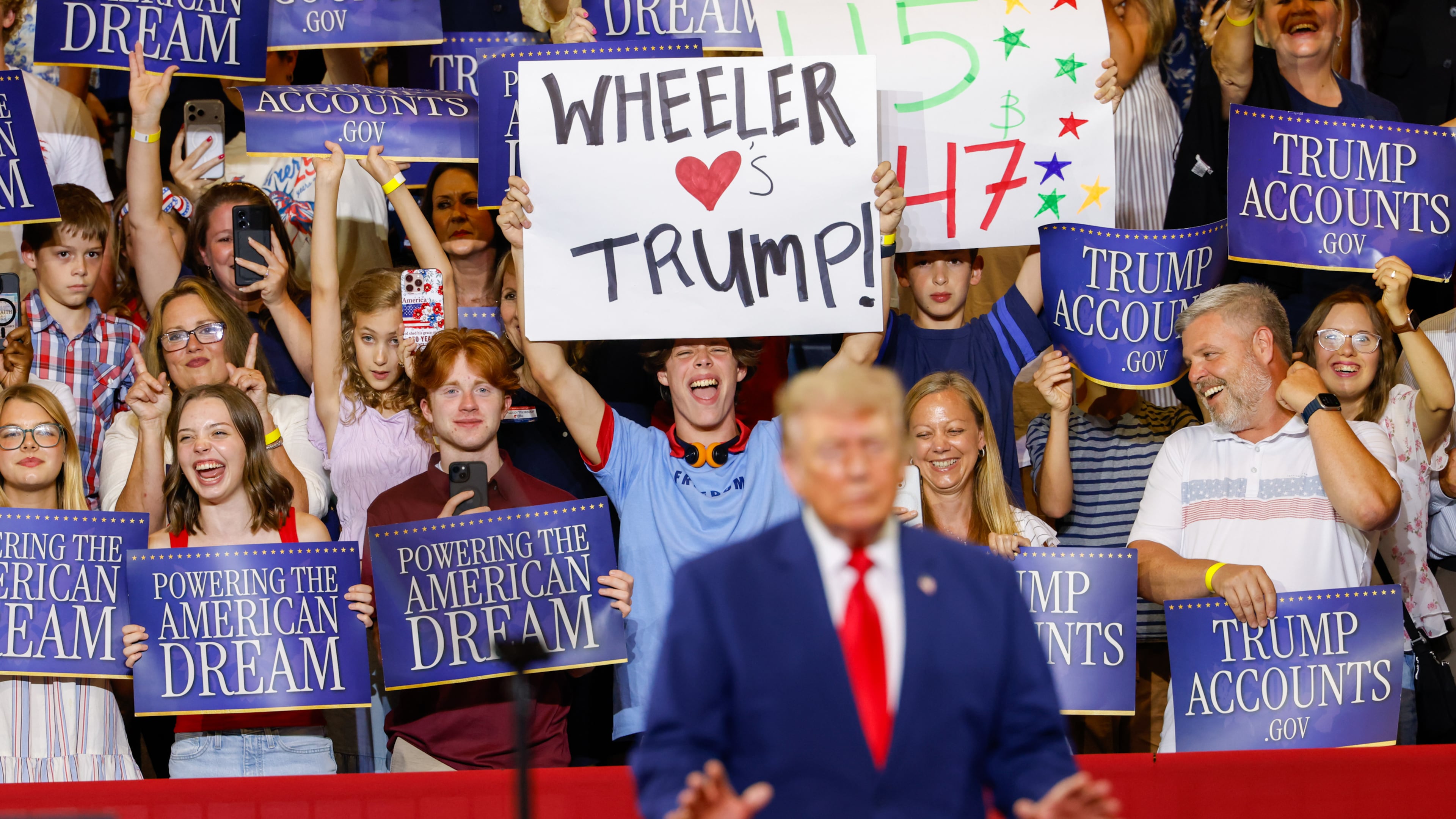 A support holds a sign that says “Wheeler Loves Trump” as President Donald Trump speaks at Wheeler High School in Marietta on July 22, 2026. (Arvin Temkar/AJC)