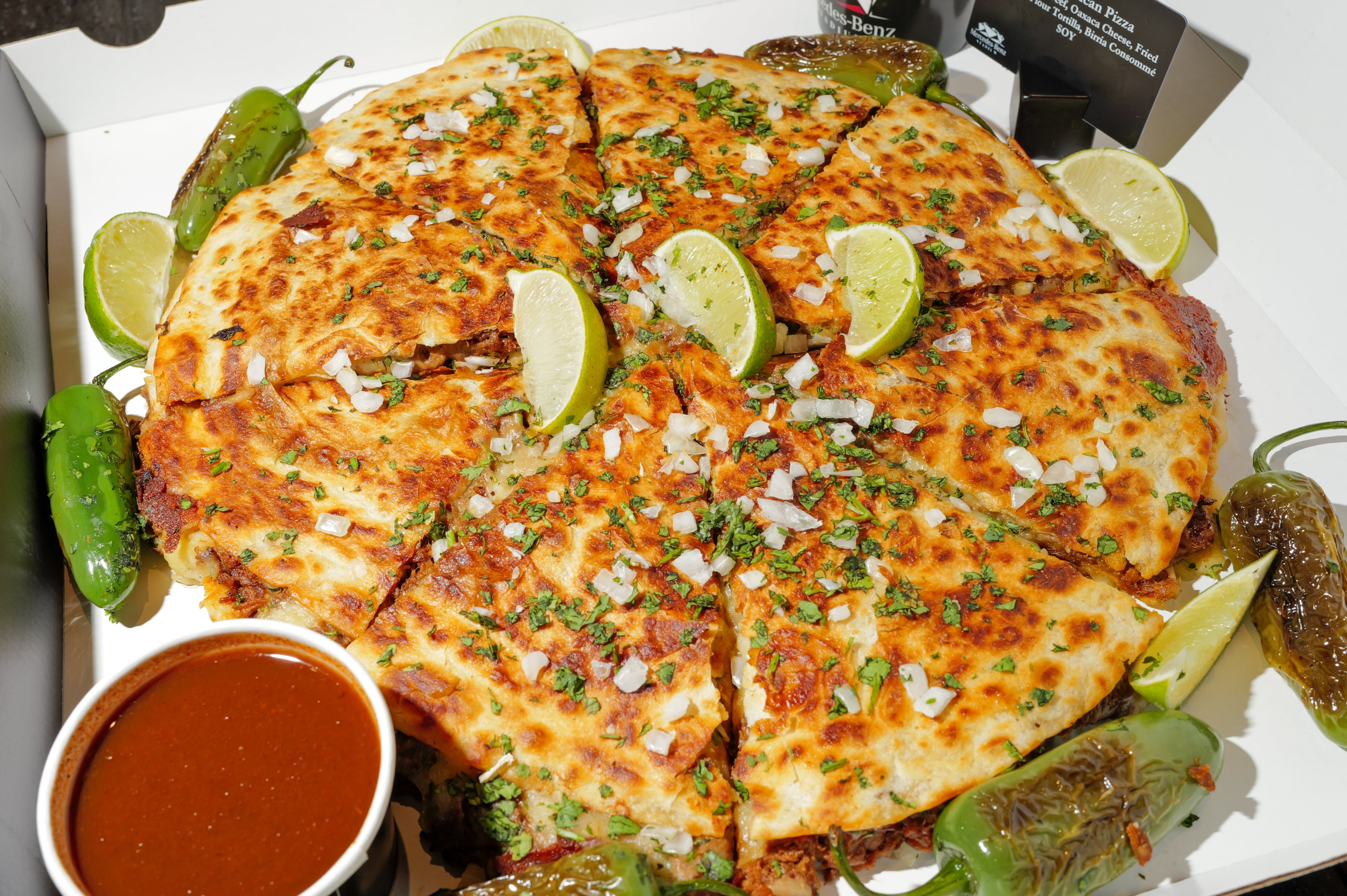 The birria Mexican pizza, which resembles a giant quesadilla, is one of the new food and beverage options at Mercedes-Benz Stadium. (Arvin Temkar/AJC)