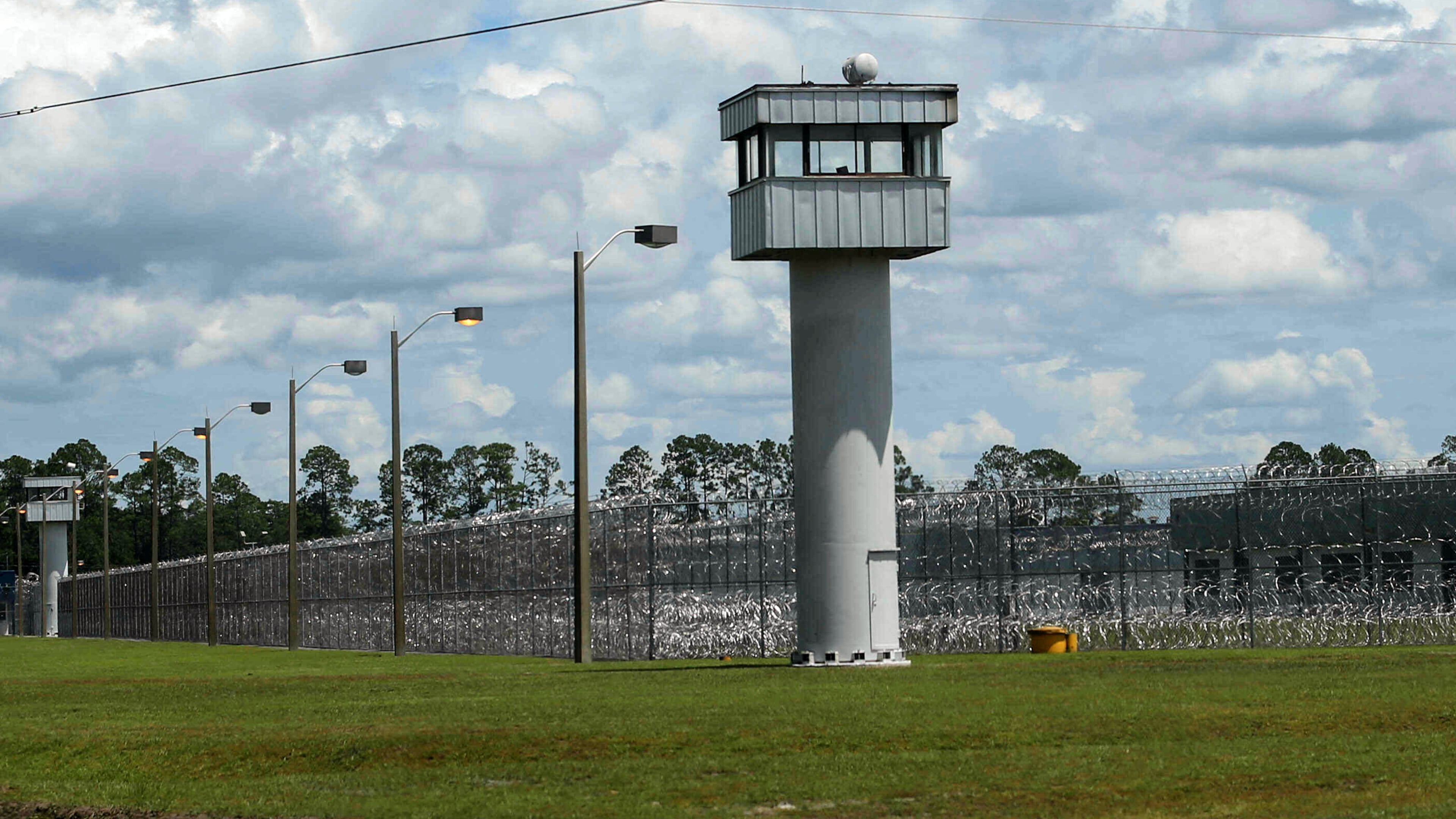 FILE - Fence and towers at the Baker Correctional Institution, Sanderson, Fla., Thursday, Aug. 14, 2025. (AP Photo/Gary McCullough, File)