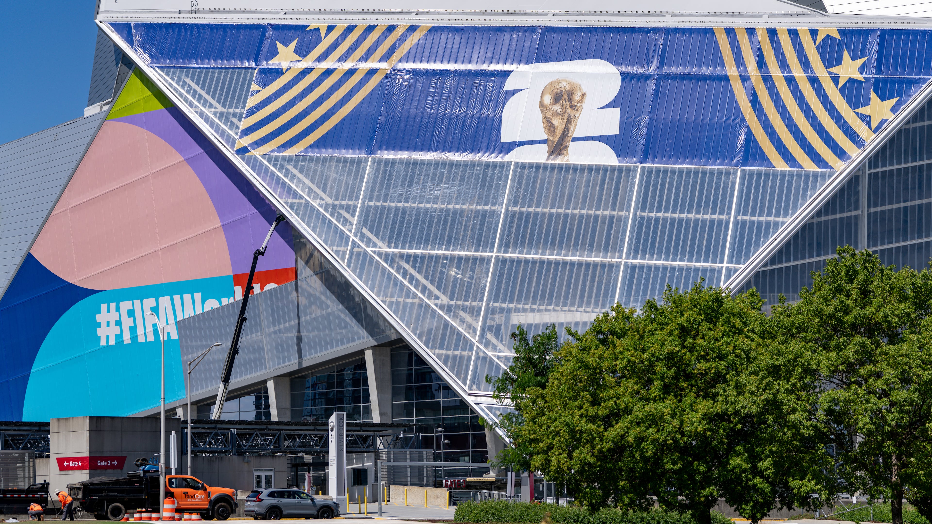 There are no plans to close streets around Mercedes-Benz Stadium — seen here getting new signage earlier this month — or Centennial Olympic Park during the World Cup, Atlanta police said. (Ben Hendren for the AJC)