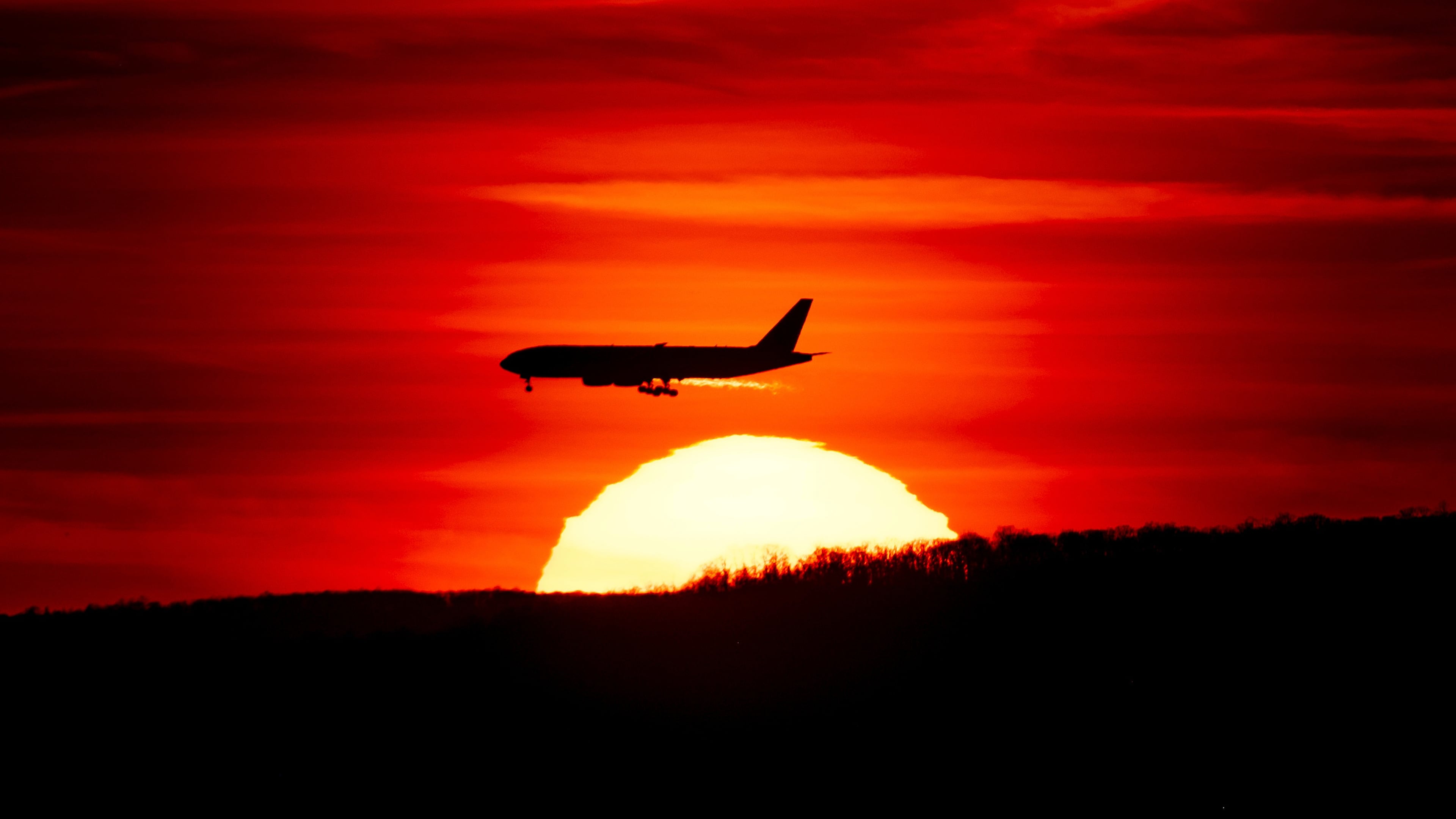 FILE - A passenger jet on approach to Newark Liberty International Airport flies over the setting sun in Newark, N.J., March 27, 2019. (AP Photo/J. David Ake, File)