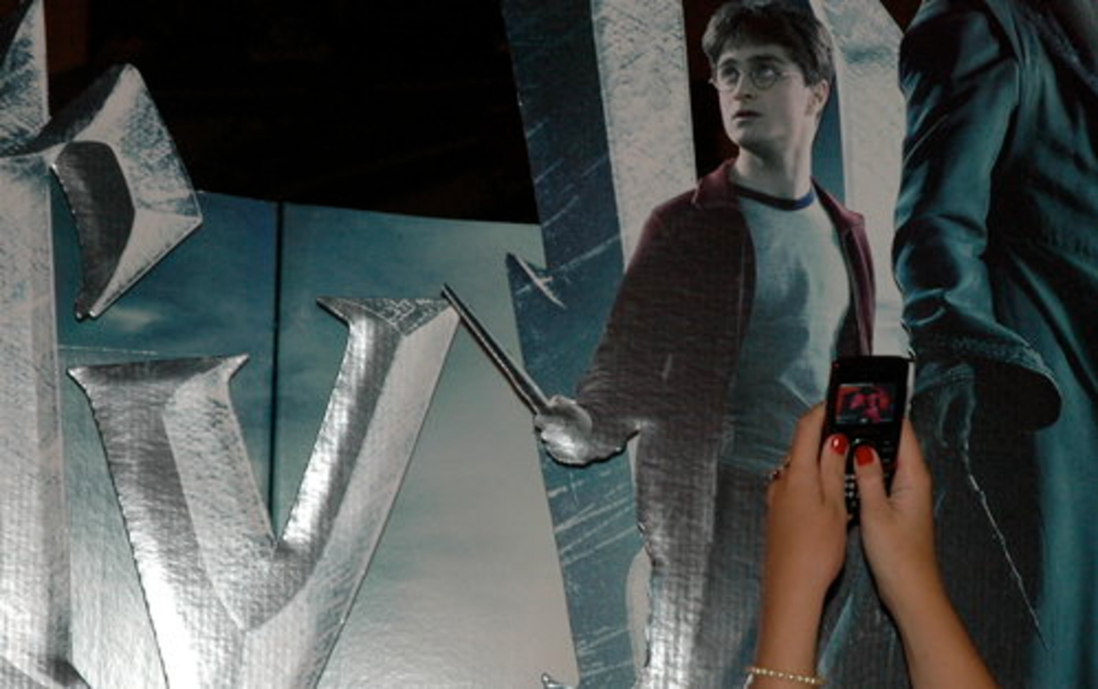 JORDAN DAVIS, 13, of Buford, shoots a photo of a "Harry Potter and the Half-Blood Prince" advertisement at the theater.