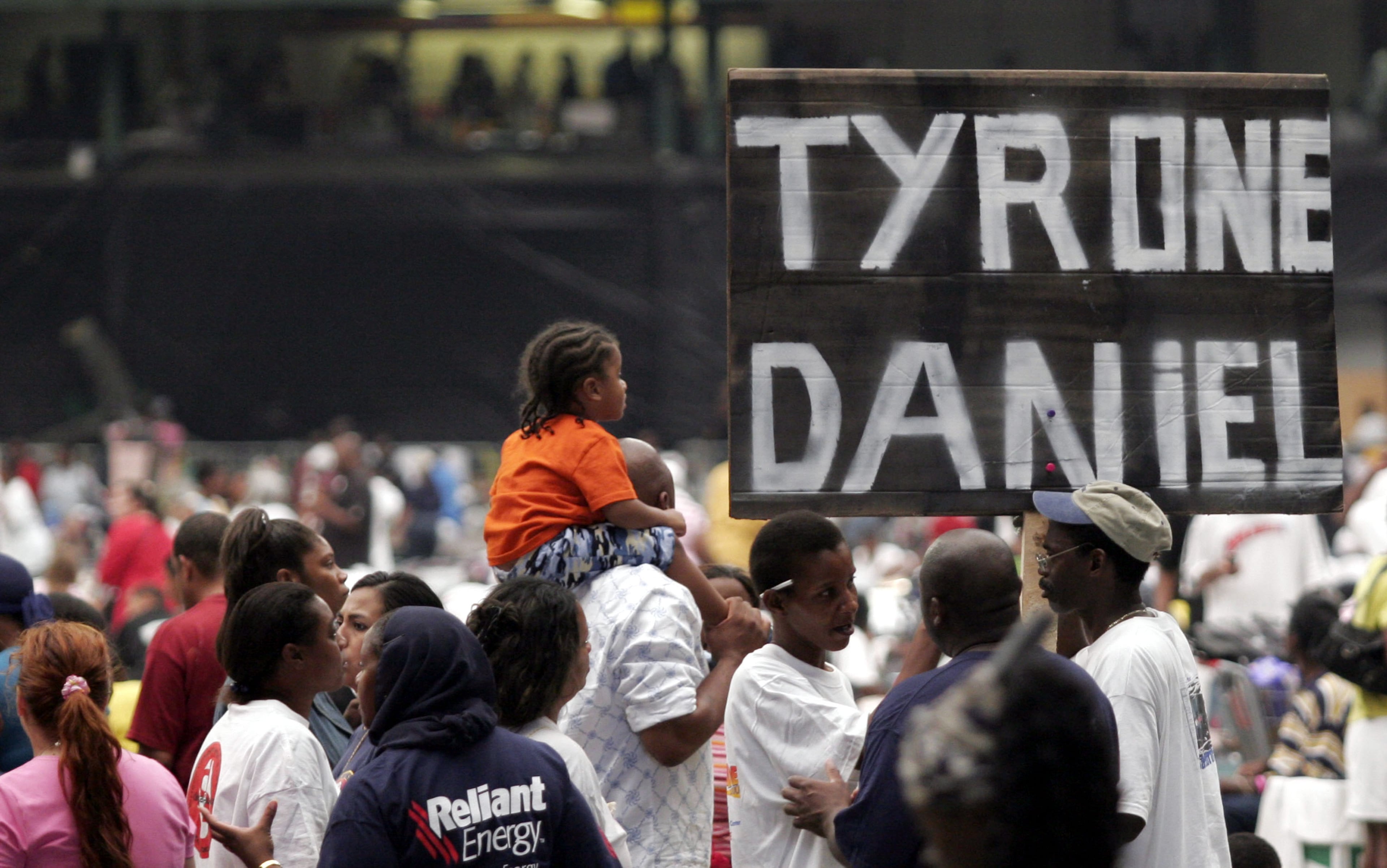 Alvin Daniel, of New Orleans, roams the floor of the Reliant Astrodome carrying a sign baring the names of his brothers, Tyrone and Daniel September 3, 2005 in Houston, Texas. Houston Mayor Bill White cleared the George R. Brown Convention Center schedule because the Reliant Astrodome is filled to capacity with victims from Hurricane Katrina. (Photo by Dave Einsel/Getty Images)