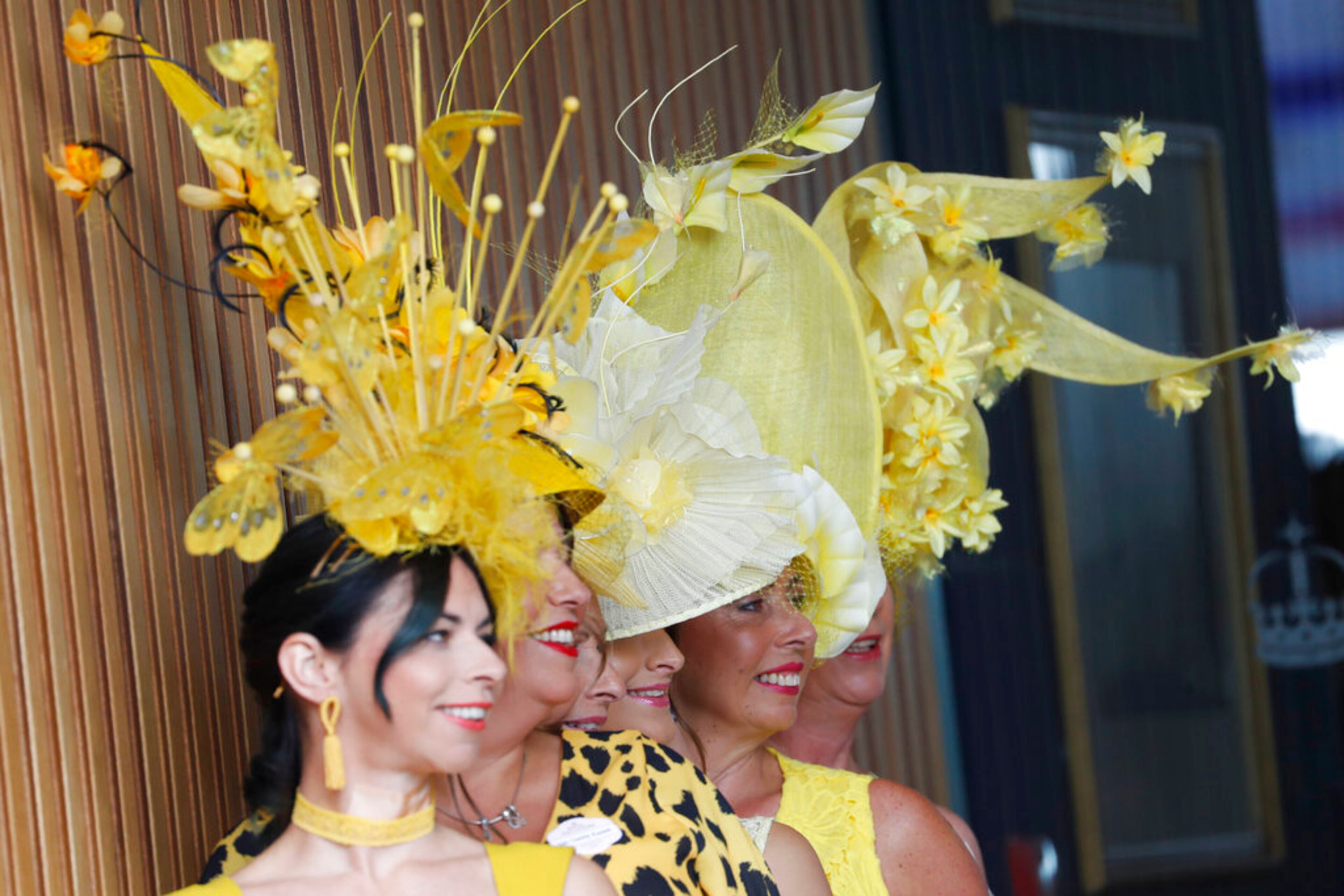 Racegoers pose for photographers as they arrive on the second day of the annual Royal Ascot horse race meeting in Ascot, England, Wednesday, June 19, 2019. (AP Photo/Alastair Grant)