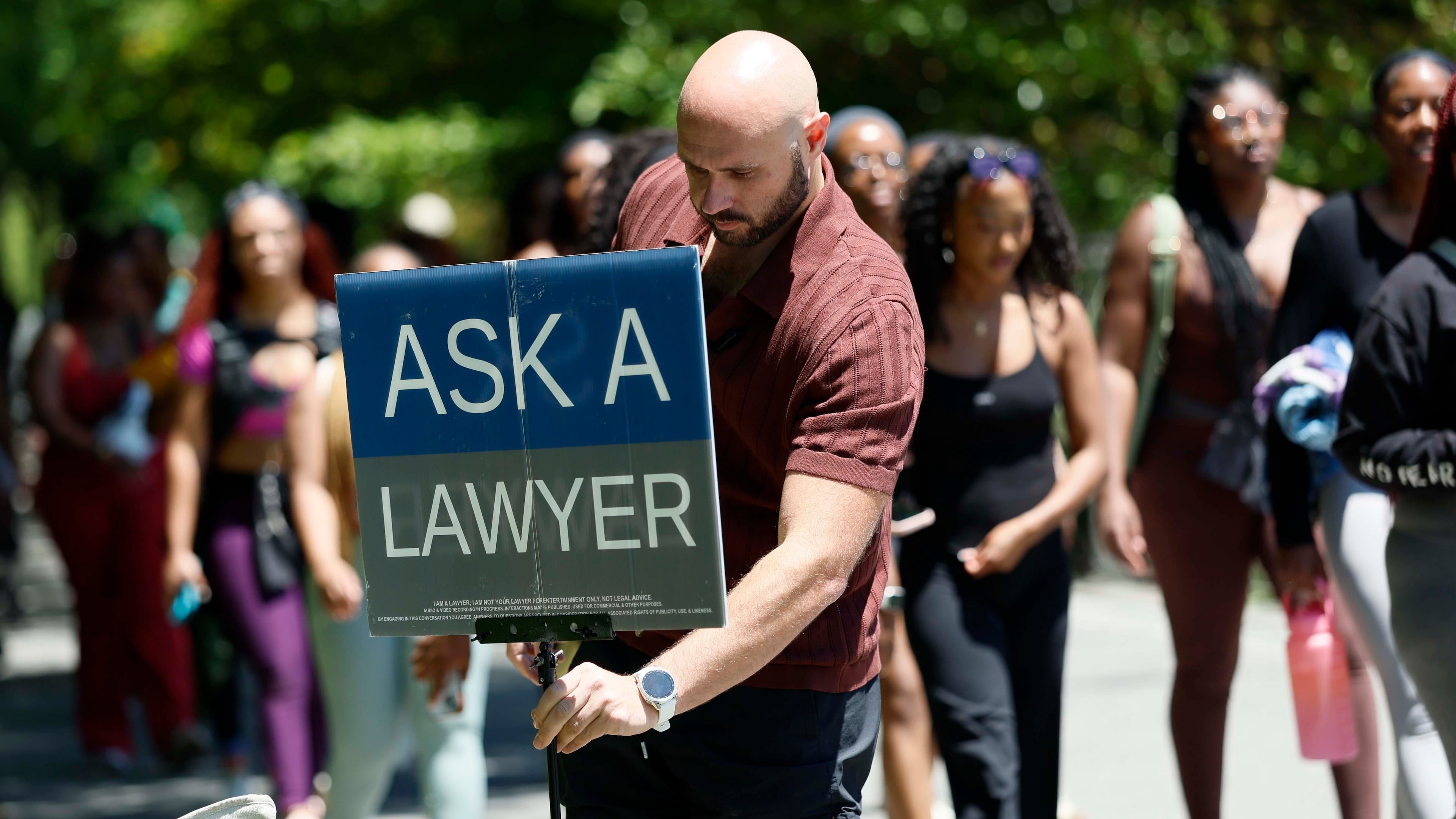 Atlanta attorney Cody Randall sets up his station on the Beltline near Krog Street Market, where he is well known for providing free legal advice to the public, on Sunday, May 3, 2026. Randall has 1.5 million followers on social media, where he posts clips of his conversations. (Miguel Martinez/AJC)