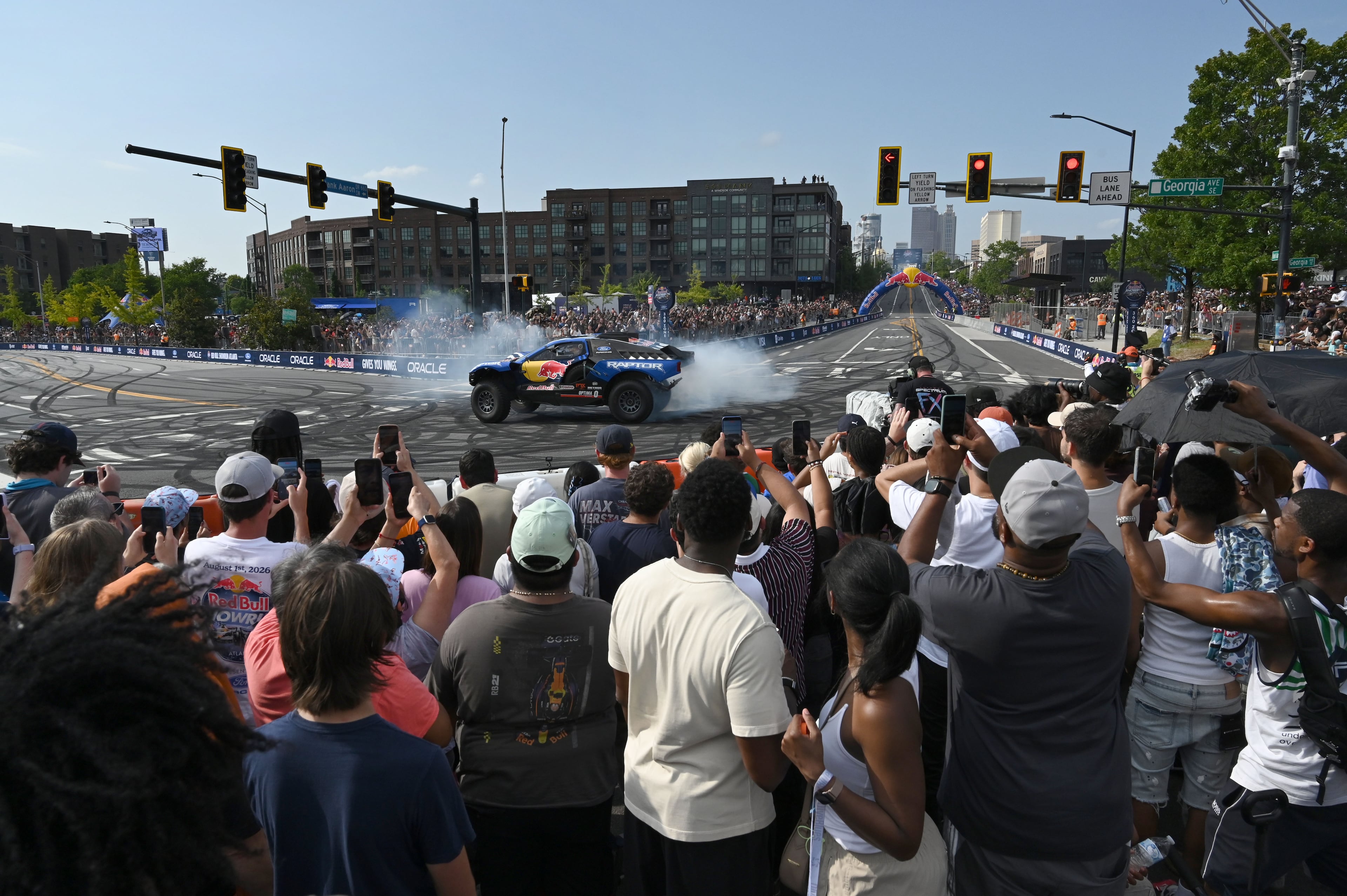 Spectators hold up their smartphones to capture a demonstration run on Hank Aaron Drive during the Red Bull Showrun Atlanta Presented by Ford Racing on Saturday, Aug. 1, 2026, in Atlanta. Atlanta city officials this week approved permits for the Red Bull Showrun that will allow the live motorsports demonstration event to go on as advertised along a roughly half-mile stretch of Hank Aaron Drive — a backup location after earlier plans to hold the event near Piedmont Park ran into opposition from Midtown residents. (Hyosub Shin/AJC)