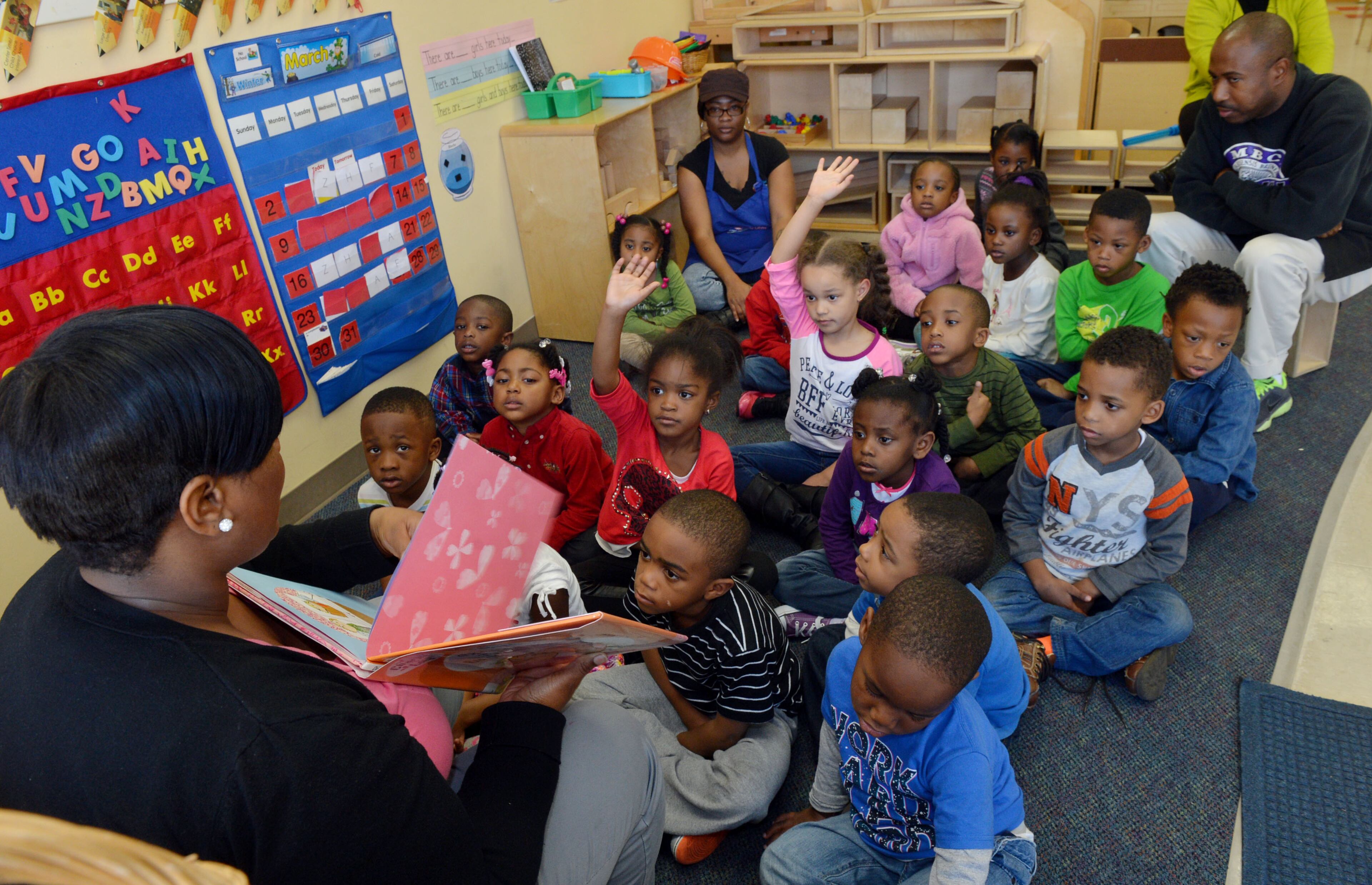 Teacher Natunya Brown reads a story to pre-K students after their naptime Wednesday. Lead teacher James Hollifield and assistant Carletta Johnson listen in. Georgia's popular, lottery funded pre-kindergarten program is paying off for 4-year-olds, giving them a leg-up on counting and six other skills they need for school, according to a study released on Wednesday. Researchers at UNC Chapel Hill's Frank Porter Graham Child Development Institute found students who completed Georgia pre-k and were headed to kindergarten performed better on seven of 10 school readiness skills than students of the same age who were just entering the program.