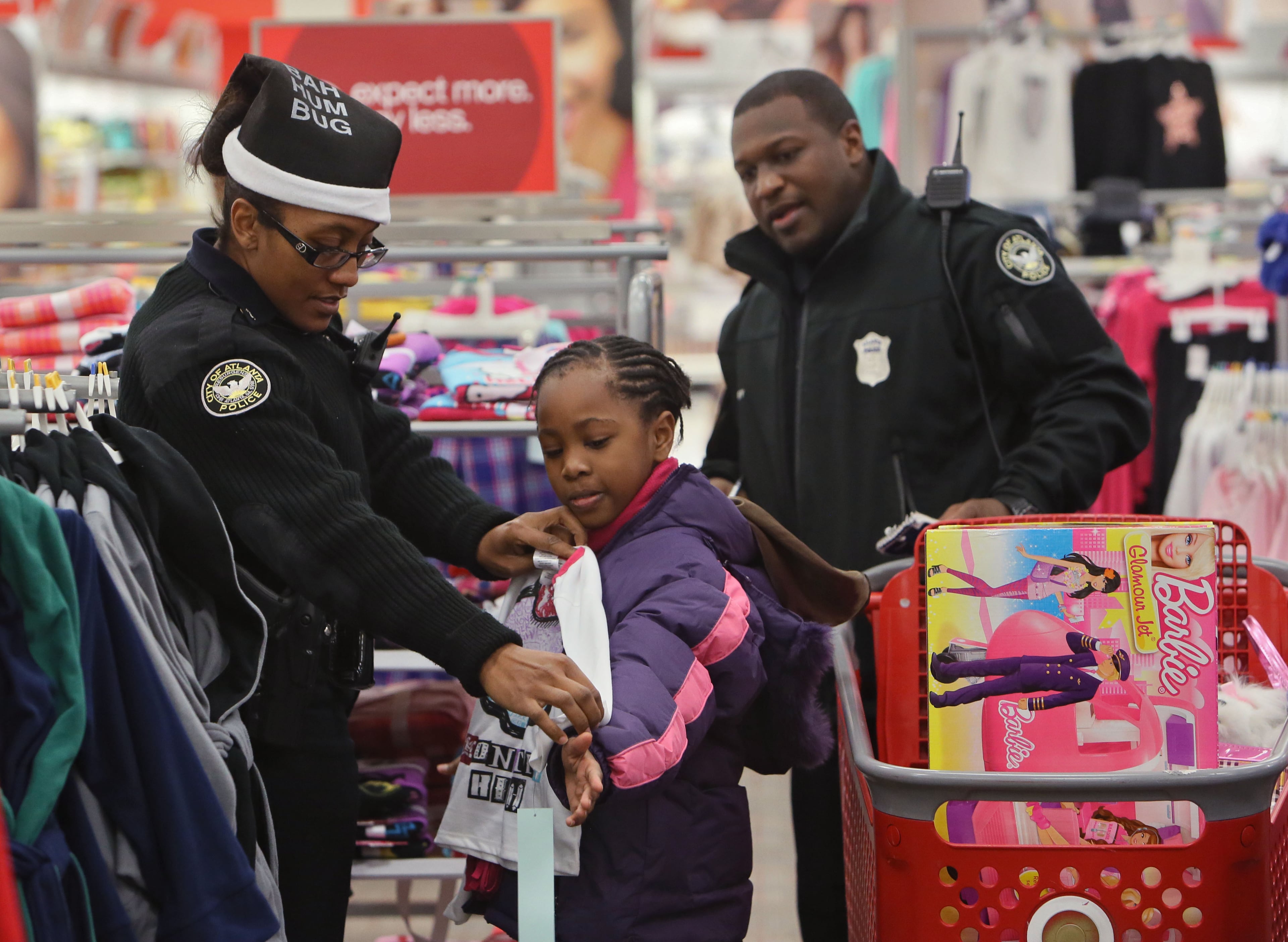 Officer F. Dodson (left) and Officer Edward Irby shop with La'Maya Gordon, 8. The International Brotherhood of Police Officers hosted its annual “Santa Cop” Thursday. Atlanta Police Officers and children shopped for gifts at the Atlantic Station Target store after breakfast at the Hard Rock Cafe. Most of the children involved with this event would not have a Christmas if this event were not held.