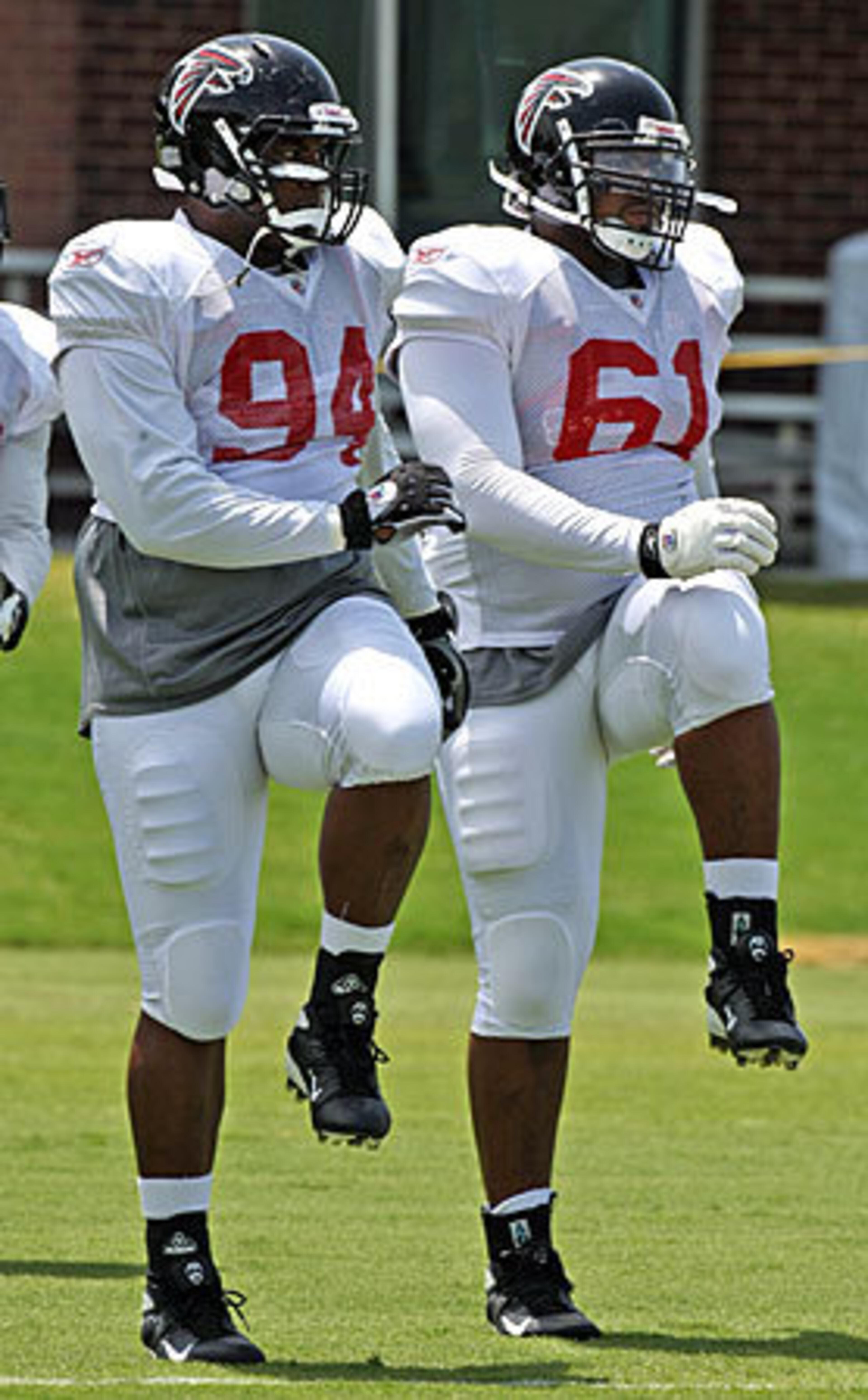Rookie defensive tackles # 94 Peria Jerry, Mississippi, and # 61 Vance Walker, Georgia Tech, appear to be in step as they loosen up for practice.