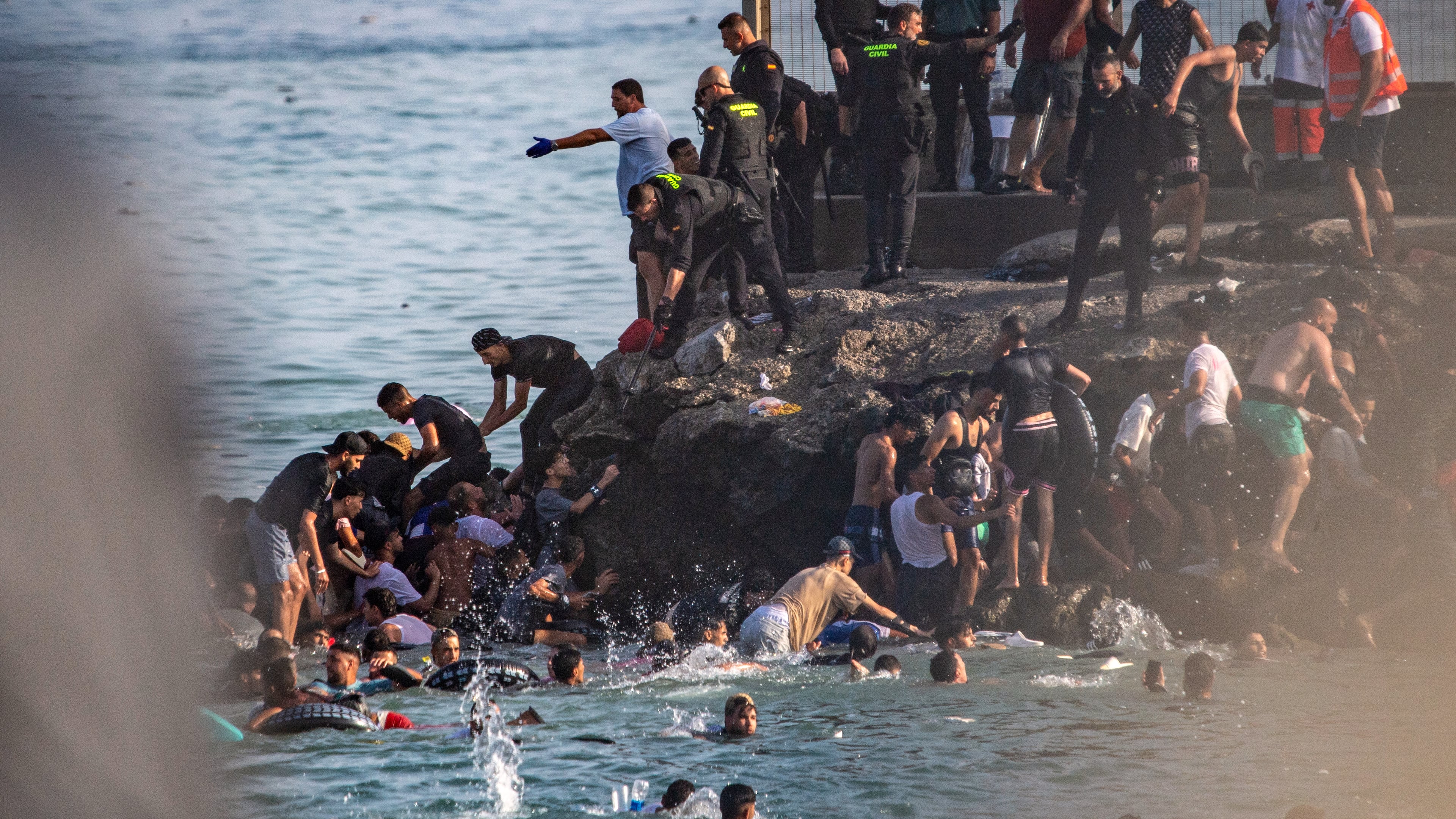 Migrants try to cross from Morocco into the Spanish enclave of Ceuta, Thursday, July 30, 2026. (AP Photo/Antonio Sempere)