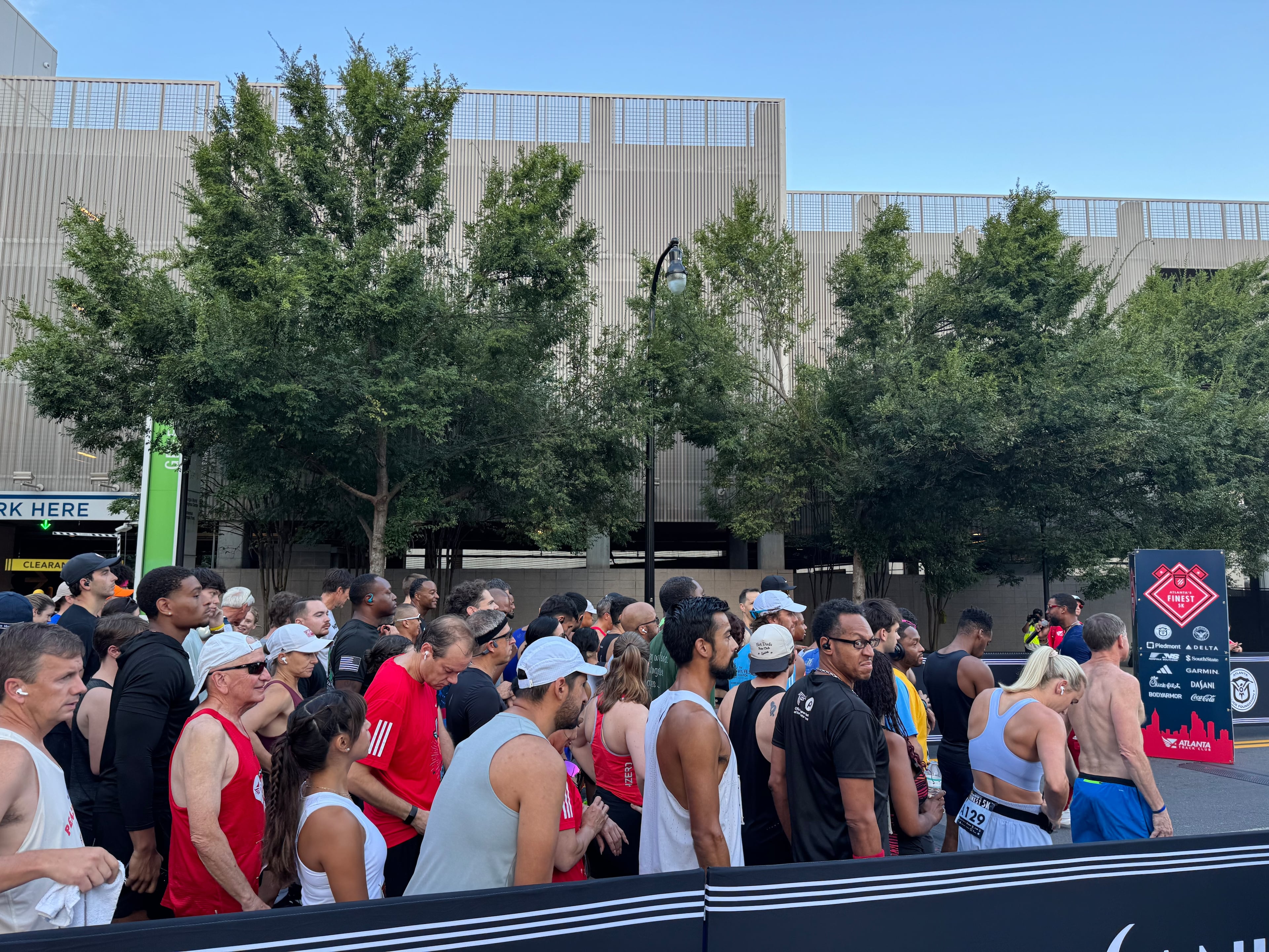 Runners line up at the start line of the Atlanta's Finest 5K race on Saturday, Aug. 16, 2025. Minutes before starting the race, runners took a moment of silence to honor David Rose, who served four years in the Marines. (Caleb Groves/AJC)