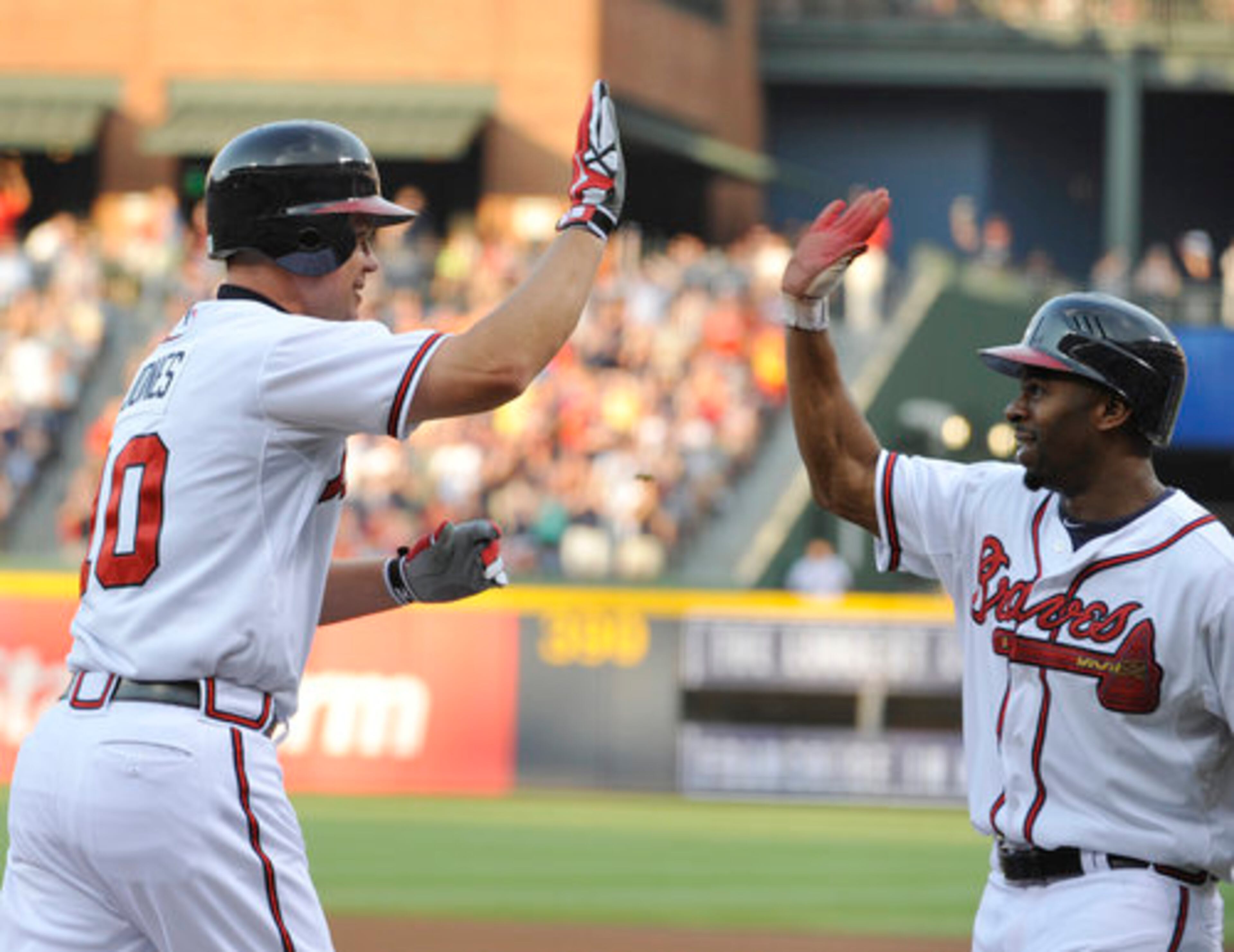 Atlanta Braves' Chipper Jones, left, high-fives teammate Michael Bourn after hitting a two-run home run in the first inning of a baseball game against the San Diego Padres, Thursday, Aug. 16, 2012, in Atlanta.