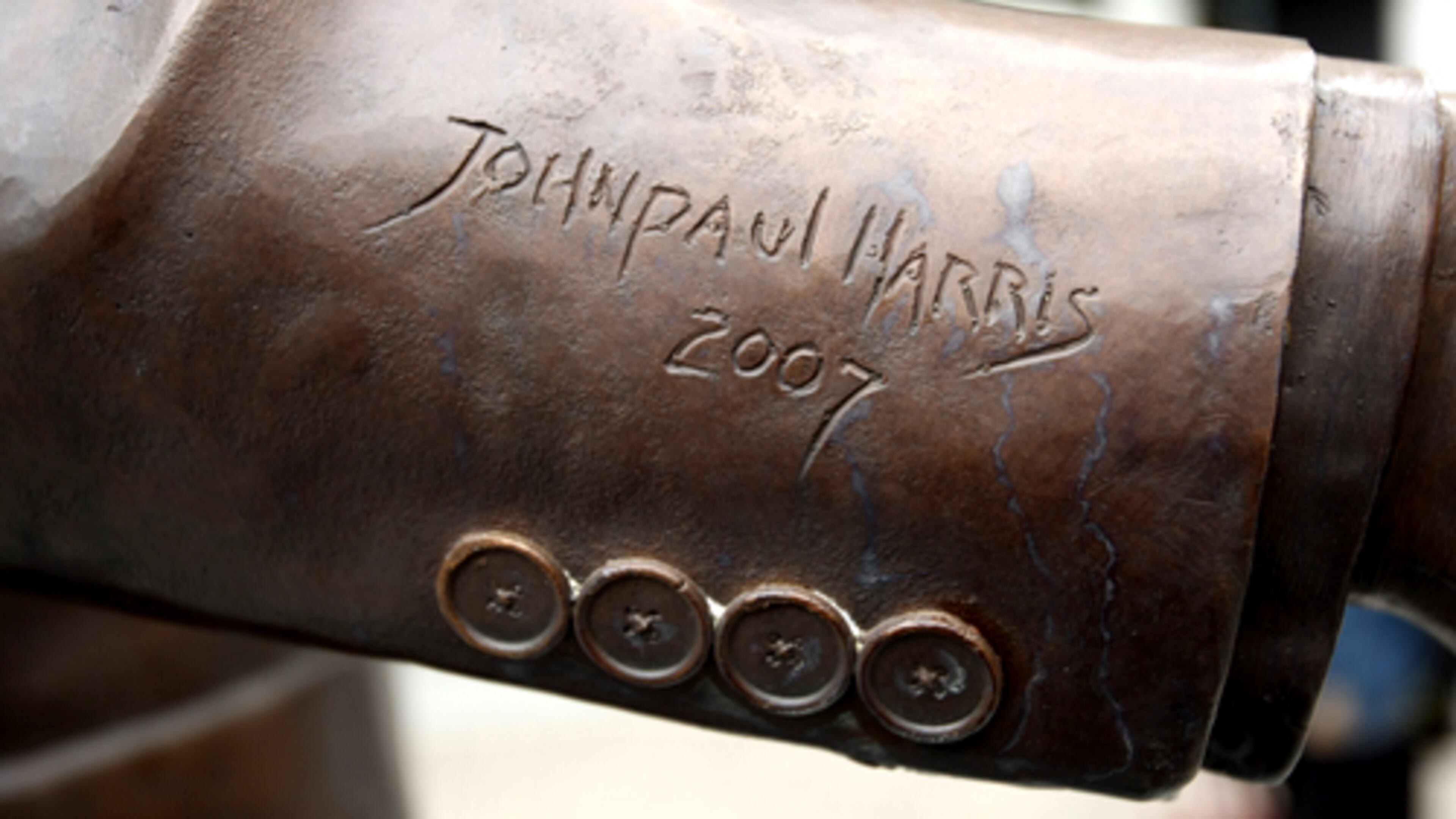 The bronze coat sleeve of the Andy Young statue is signed by the sculptor. John Spink/AJC