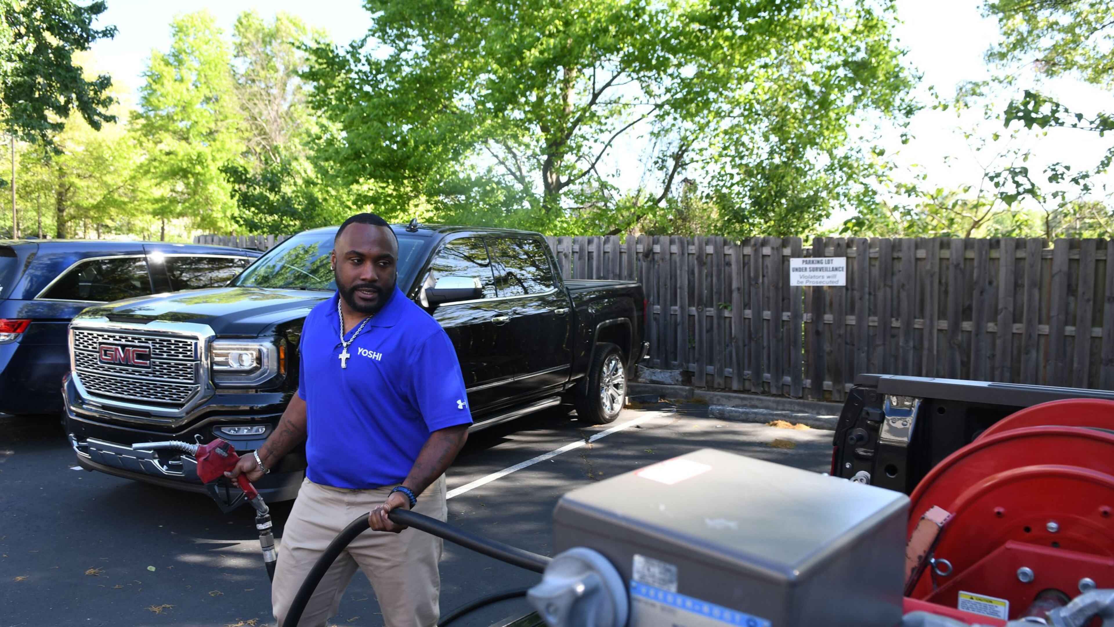 Brian Glanton, a field technician and supervisor for Yoshi, fills up a gas tank in an Atlanta area parking lot. Yoshi, a San Francisco venture backed by Exxon and GM, is doubling down on its operations in metro Atlanta, where it delivers fuel directly to customers’ vehicles at work or home. (Rebecca Breyer)