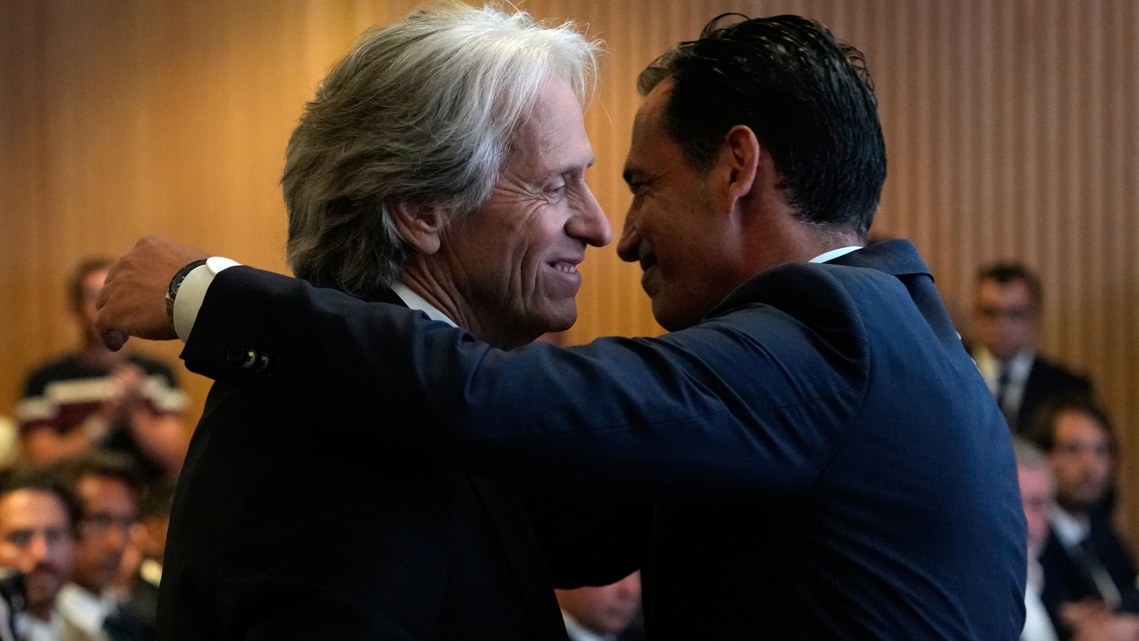 Jorge Jesus, left, is embraced by Portuguese Federation President Jorge Proenca after being presented to the media as the new Portugal soccer head coach at the Portuguese Football Federation in Oeiras, outside Lisbon, Friday, July 10, 2026. (AP Photo/Armando Franca)