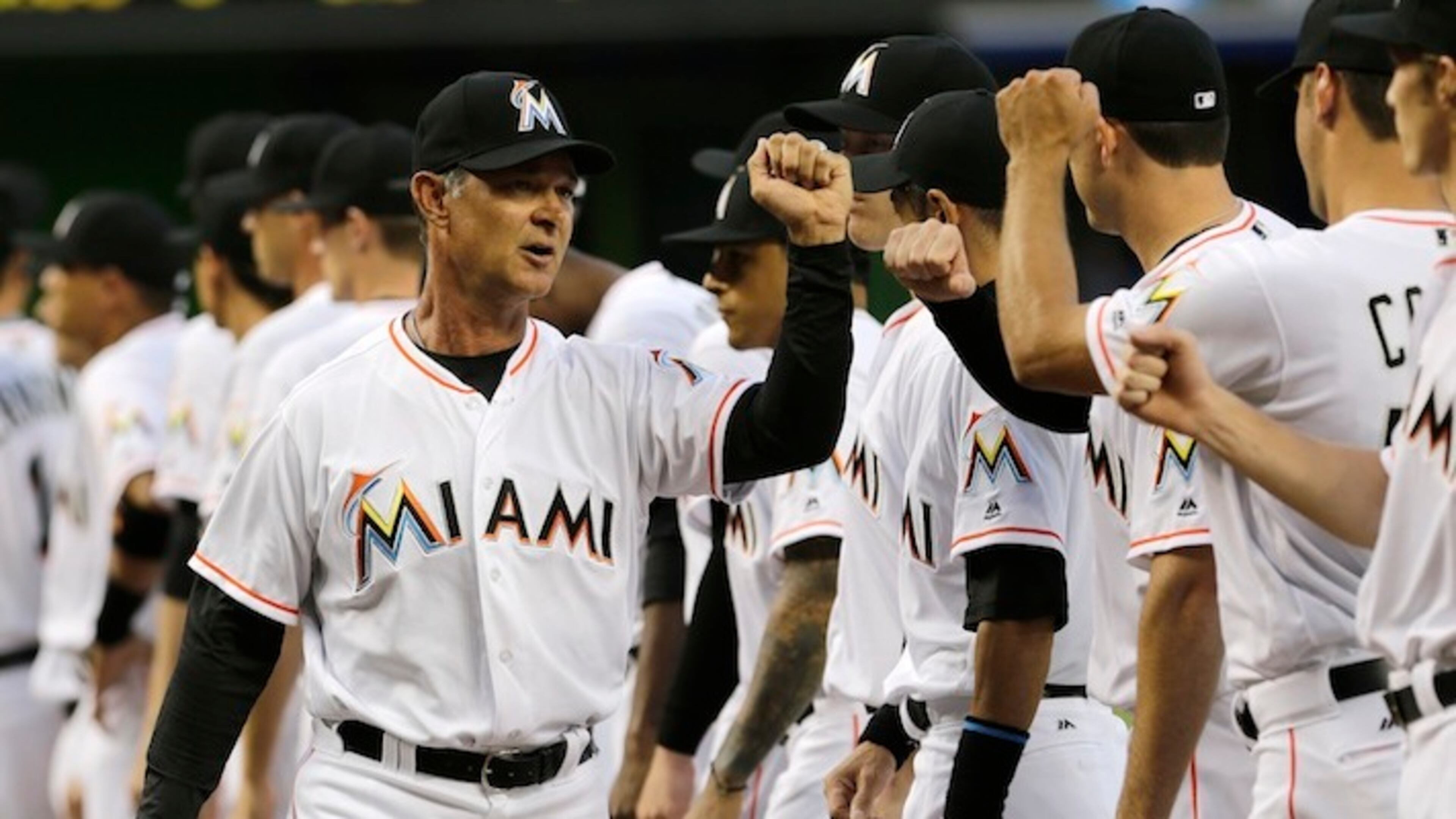 Miami Marlins manager Don Mattingly , left, greets his players during a ceremony before an interleague opening day baseball game between the Miami Marlins and the Detroit Tigers, Tuesday, April 5, 2016, in Miami. (AP Photo/Alan Diaz)