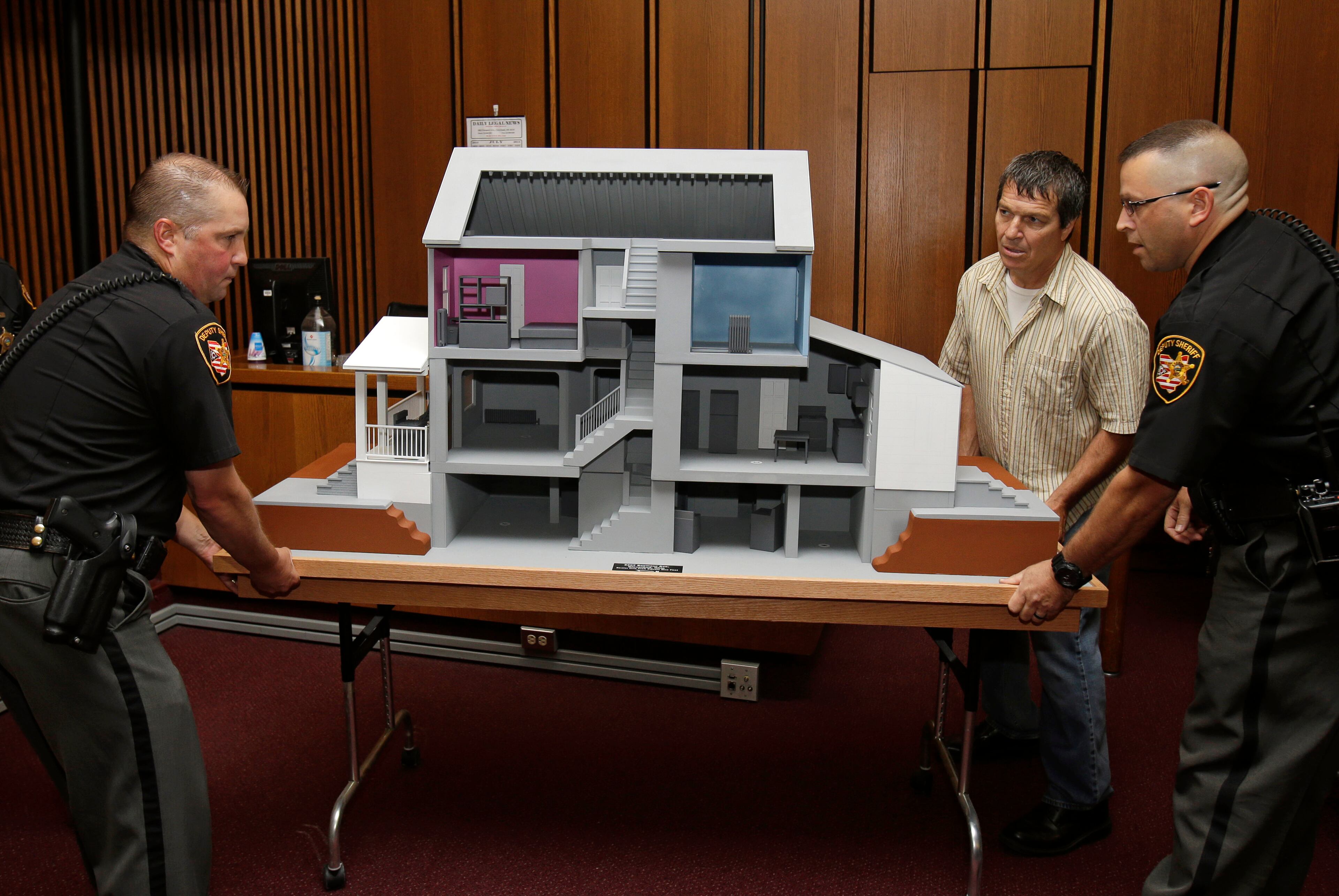 Sheriff's deputies set in place a model of the house on Seymour Ave. where Ariel Castro held three women Thursday, Aug. 1, 2013, in Cleveland. Three months after an Ohio woman kicked out part of a door to end nearly a decade of captivity, Castro, a onetime school bus driver faces sentencing for kidnapping three women and subjecting them to years of sexual and physical abuse. (AP Photo/Tony Dejak)