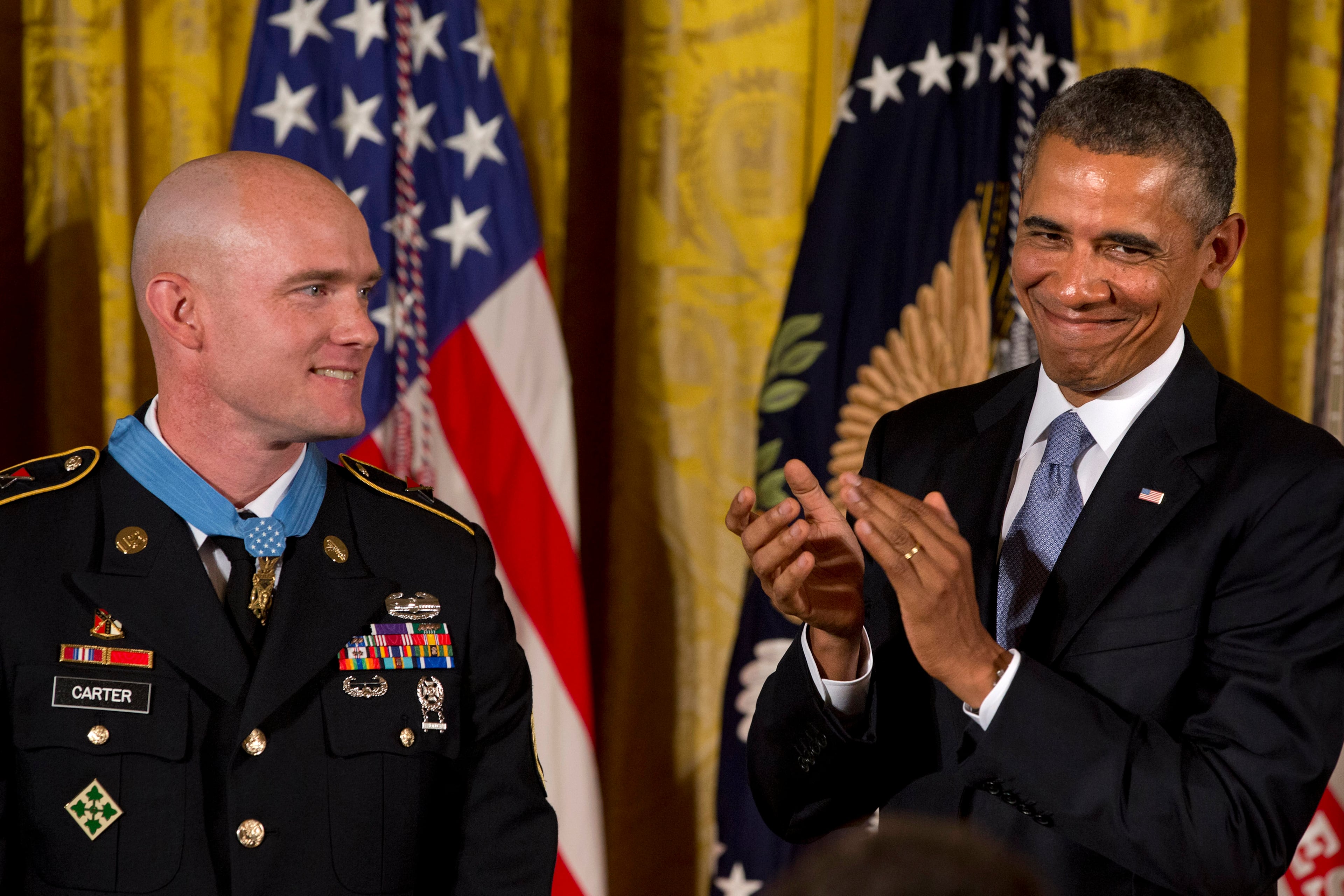 President Barack Obama applauds after awarding US Army Staff Sgt. Ty M. Carter, left, the Medal of Honor for conspicuous gallantry, Monday, Aug. 26, 2013, during a ceremony in the East Room of the White House in Washington. Carter received the medal for his courageous actions while serving as a cavalry scout with Bravo Troop, 3rd Squadron, 61st Cavalry Regiment, 4th Brigade Combat Team, 4th Infantry Division, during combat operations in Kamdesh District, Nuristan Province, Afghanistan on Oct. 3, 2009. Carter is the fifth living recipient to be awarded the Medal of Honor for actions in Iraq or Afghanistan. (AP Photo/Jacquelyn Martin)