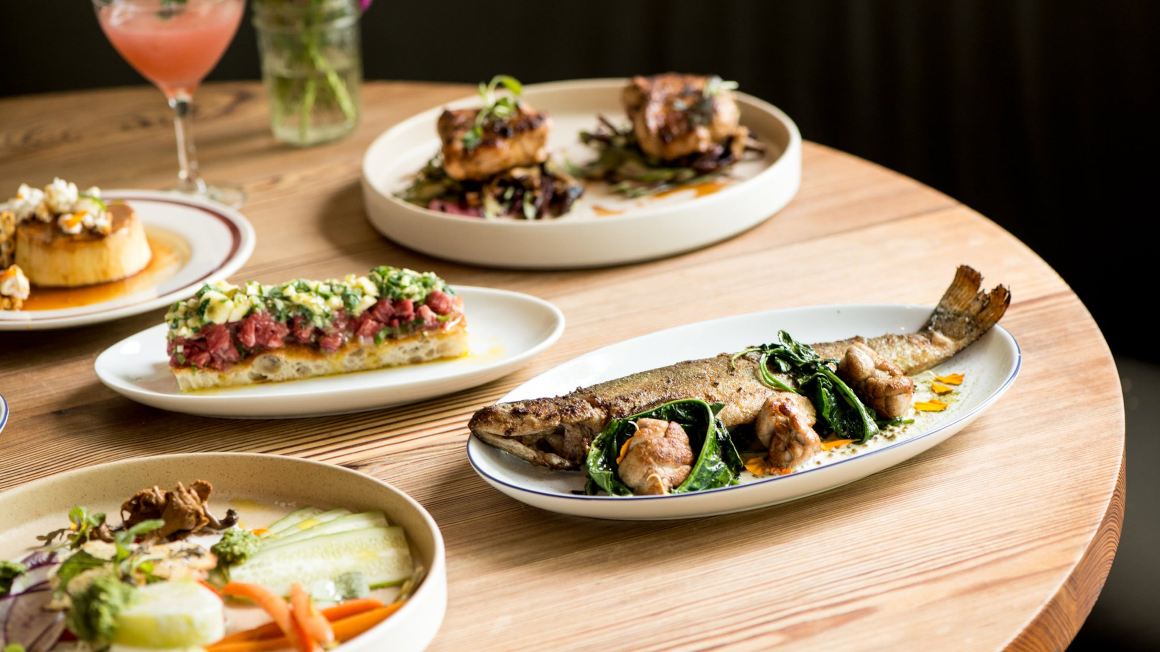 The Deer and the Dove Whole Wood Roasted Bramlett Farm Trout, Tartare, Miso Rabbit Loin, Vegetables From Our Friends, Something Genteel cocktail and Creme Caramel dessert. Photo credit- Mia Yakel.