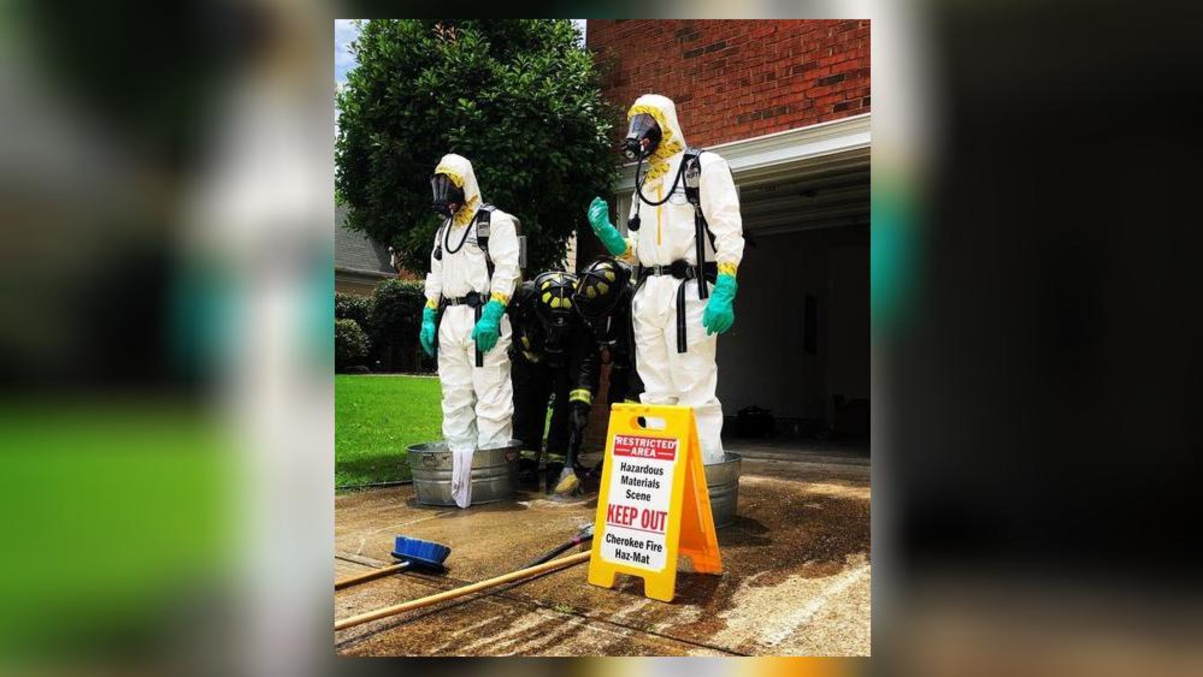 Cherokee County's hazardous materials unit stands outside a Woodstock home that deputies said was used to process heroin.