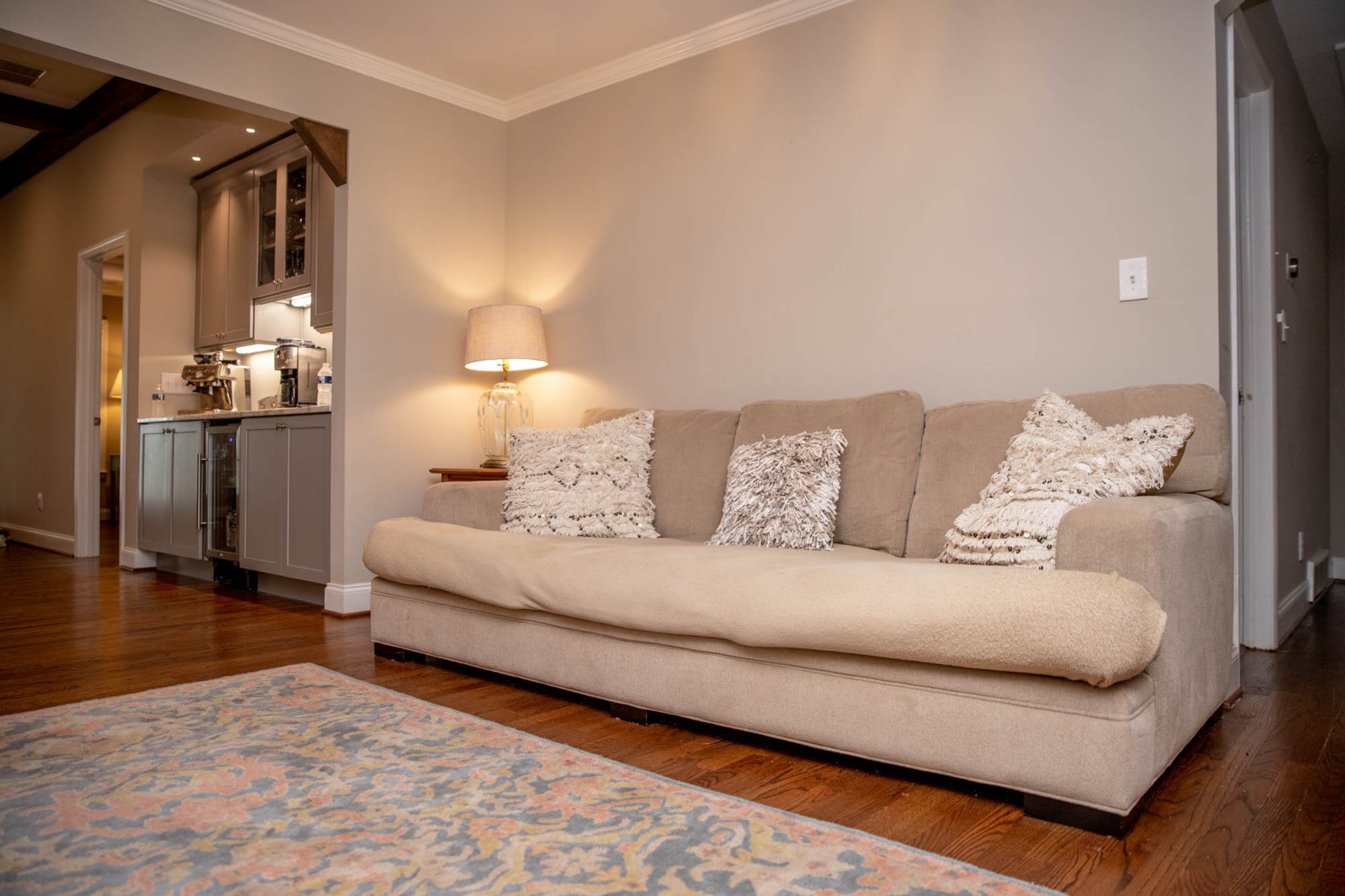 A sitting area off of the main living room is homeowner Allie Ott's favorite place to sip her morning coffee. A sofa from Rooms To Go topped with pillows from Pottery Barn fits in with the home's neutral decor, while a rug from Ballard Designs brings in hints of blue.